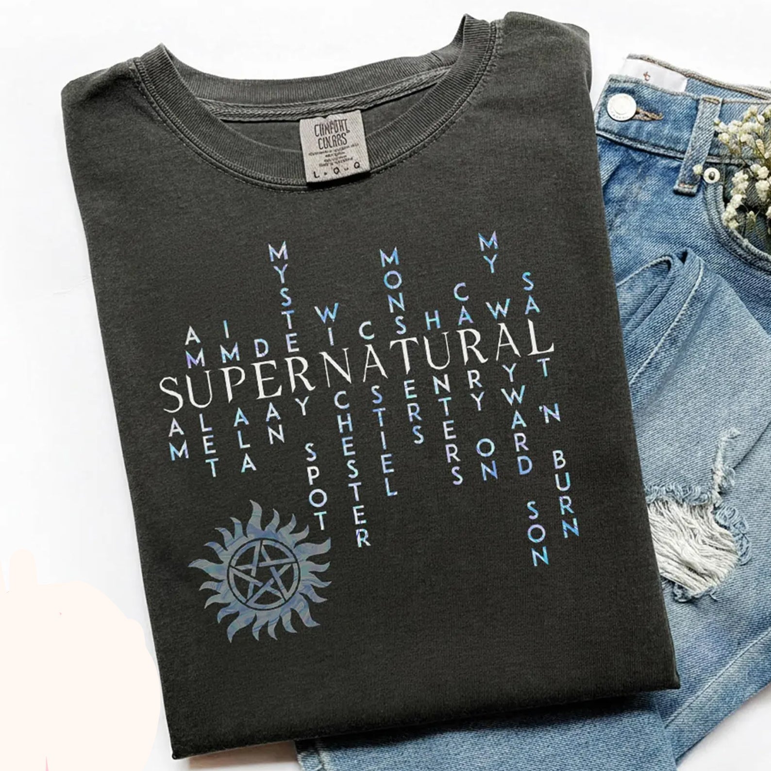 Black graphic tee featuring supernatural words design from Anchored Grace Boutique, casual apparel for fans of mystical themes.