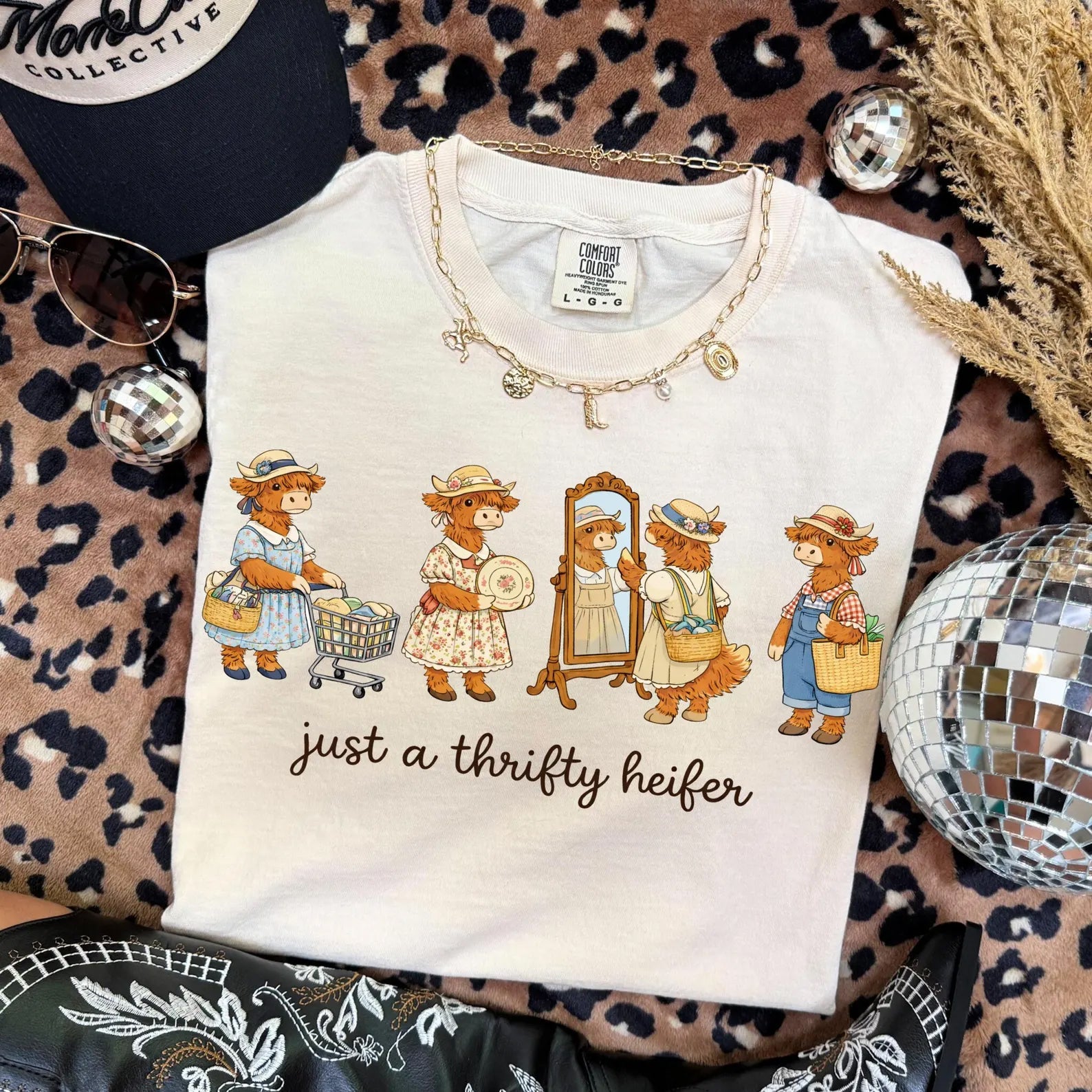 Black graphic tee featuring a playful "Just a Thrifty Heifer" design from Anchored Grace Boutique, casual and stylish for everyday wear.