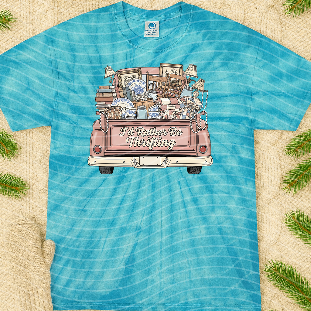 Pink graphic tee from Anchored Grace Boutique with "I'd Rather be Thrifting" slogan, casual style, short-sleeve design.