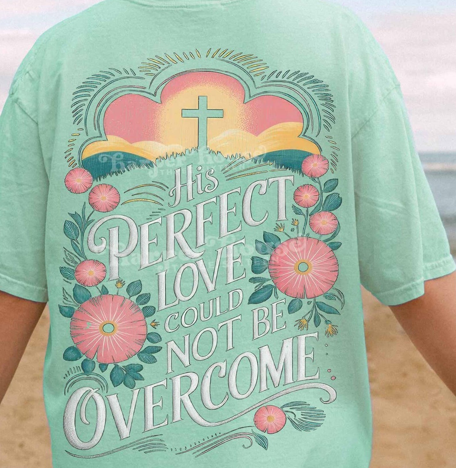 Gray graphic tee from Anchored Grace Boutique featuring the quote "His Perfect Love Could Not Be Overcome" in stylish lettering.
