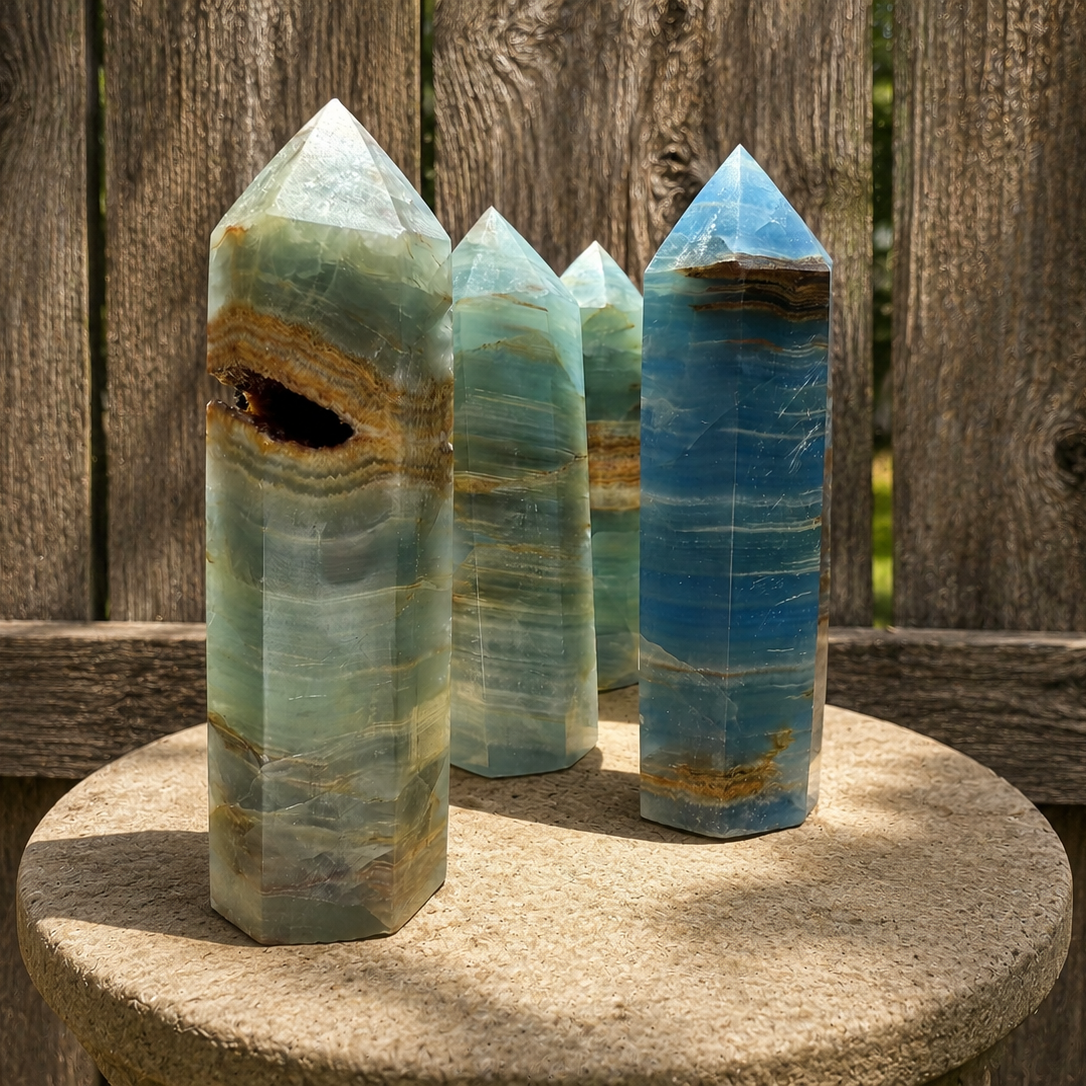 Blue Lemurian Aquatine Onyx tower crystal with deep blue and black tones, polished and standing upright for display or healing purposes.