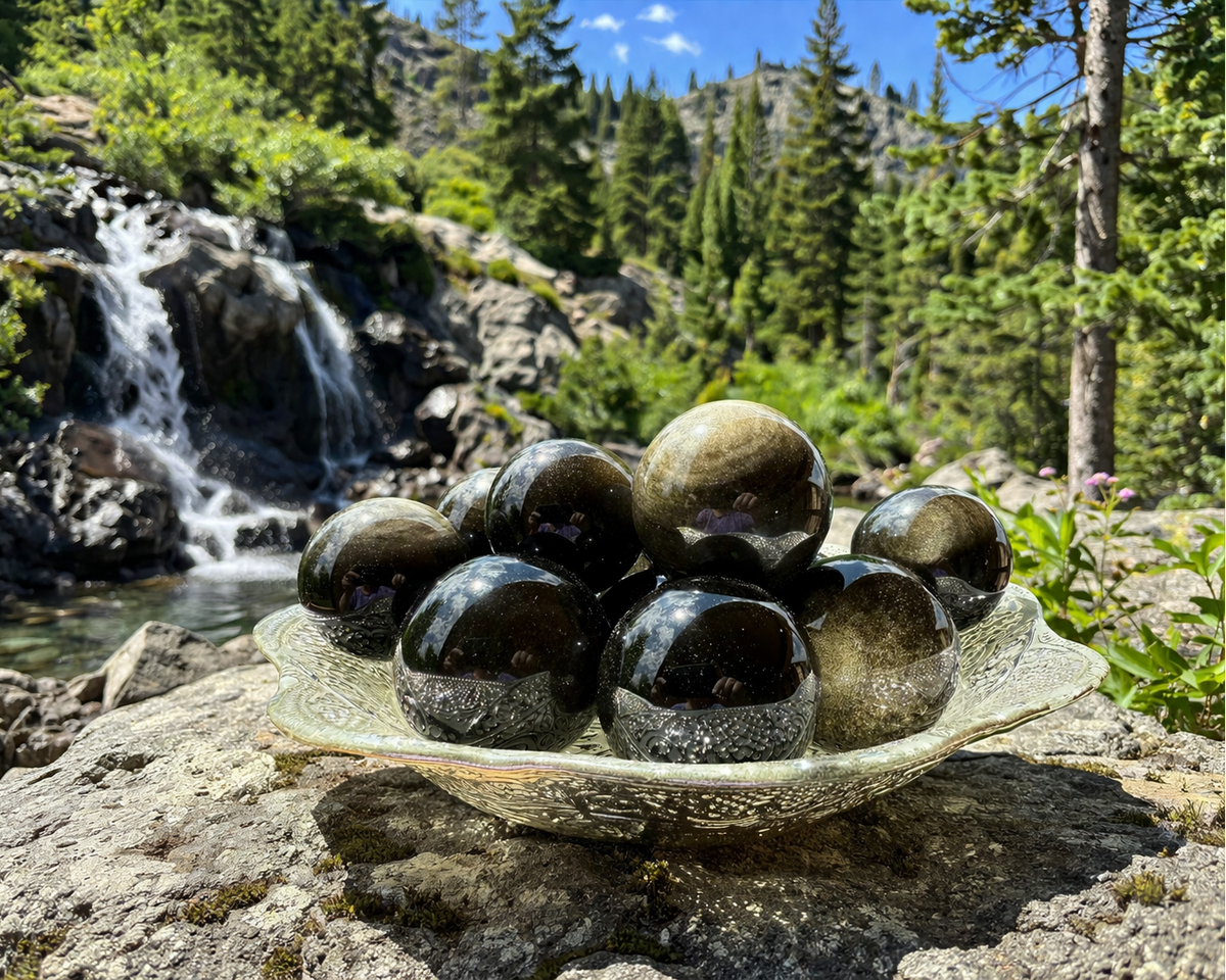 Natural gold and silver sheen obsidian sphere with smooth, polished surface, showcasing the striking iridescent mineral pattern.