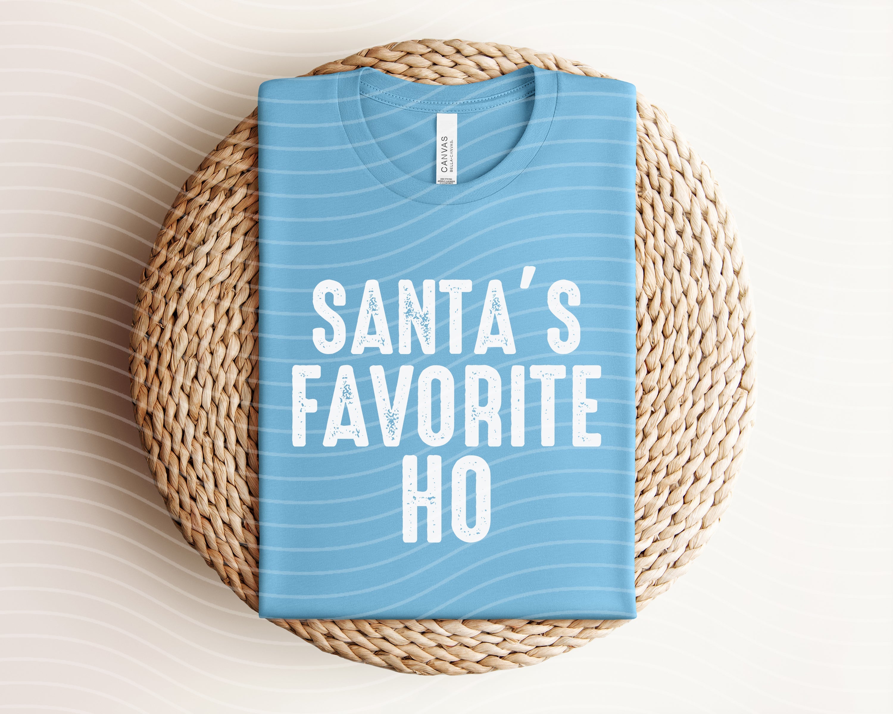 Red graphic tee featuring "Santa's Favorite Ho" slogan from Anchored Grace Boutique, with festive holiday design.