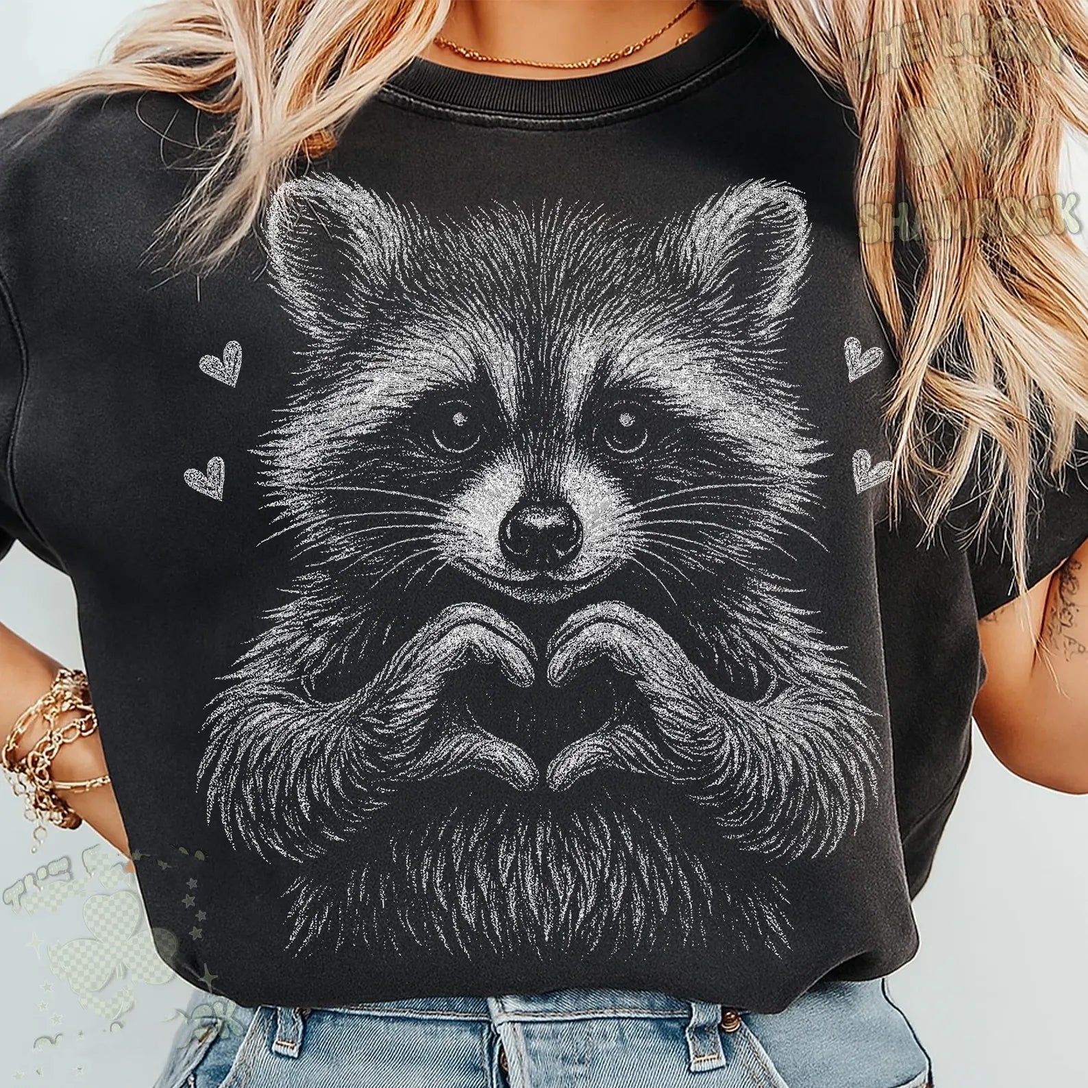 Black and white raccoon graphic tee from Anchored Grace Boutique, featuring a playful raccoon illustration on a casual t-shirt.