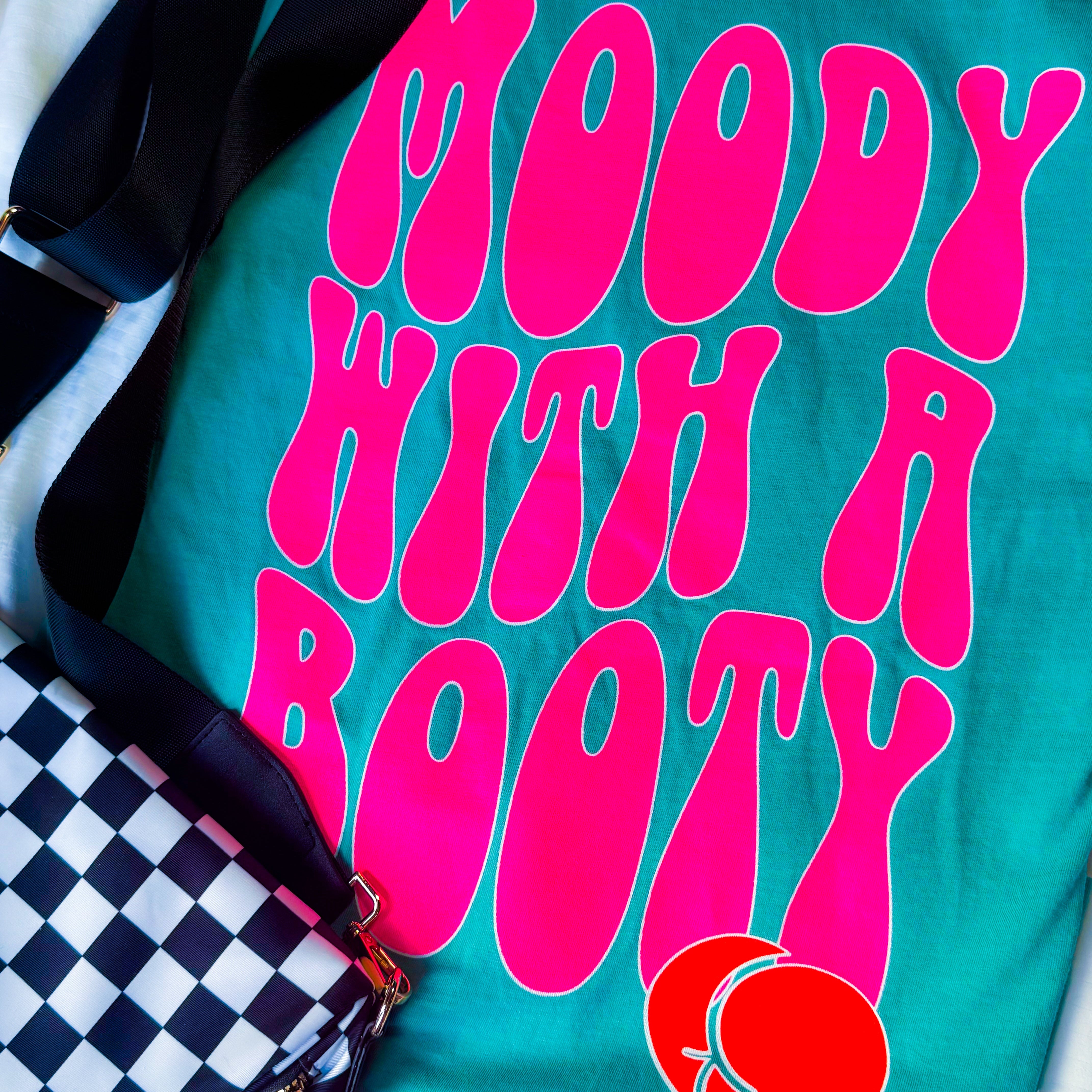 Black graphic t-shirt from Shop Karma Tees featuring the Moody with a Booty design, casual fit with bold print.