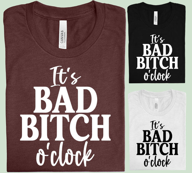 Black graphic tee by Anchored Grace Boutique featuring bold "It's Bad B**** O'Clock" text in stylish font.