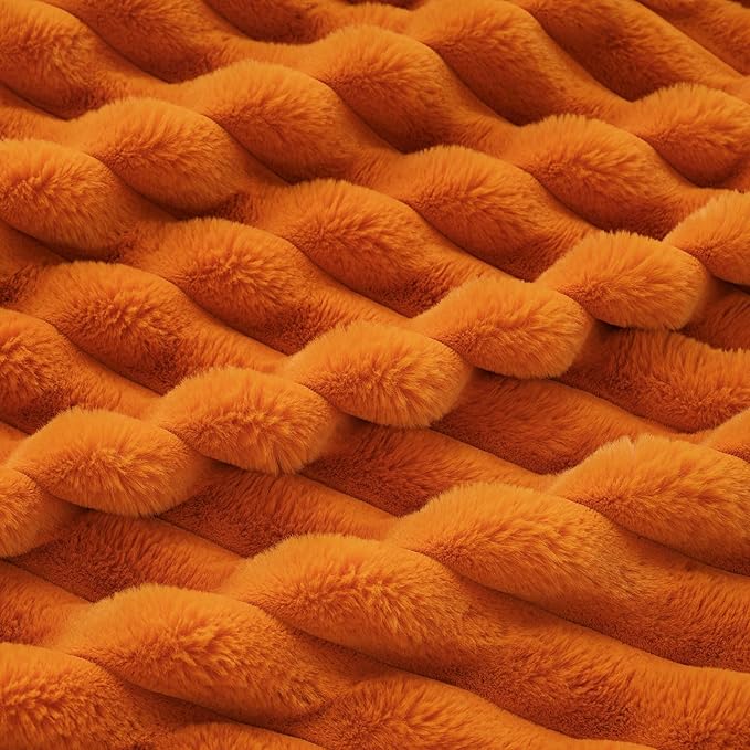CozyNest Decor fall harvest faux fur throw blanket in burnt orange, plush striped design on a sofa for cozy home decor.