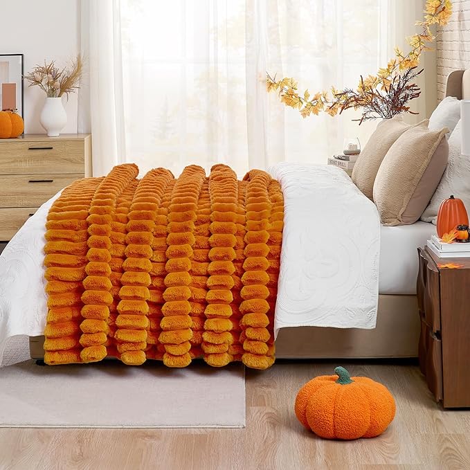 CozyNest Decor fall harvest faux fur throw blanket in burnt orange, plush striped design on a sofa for cozy home decor.