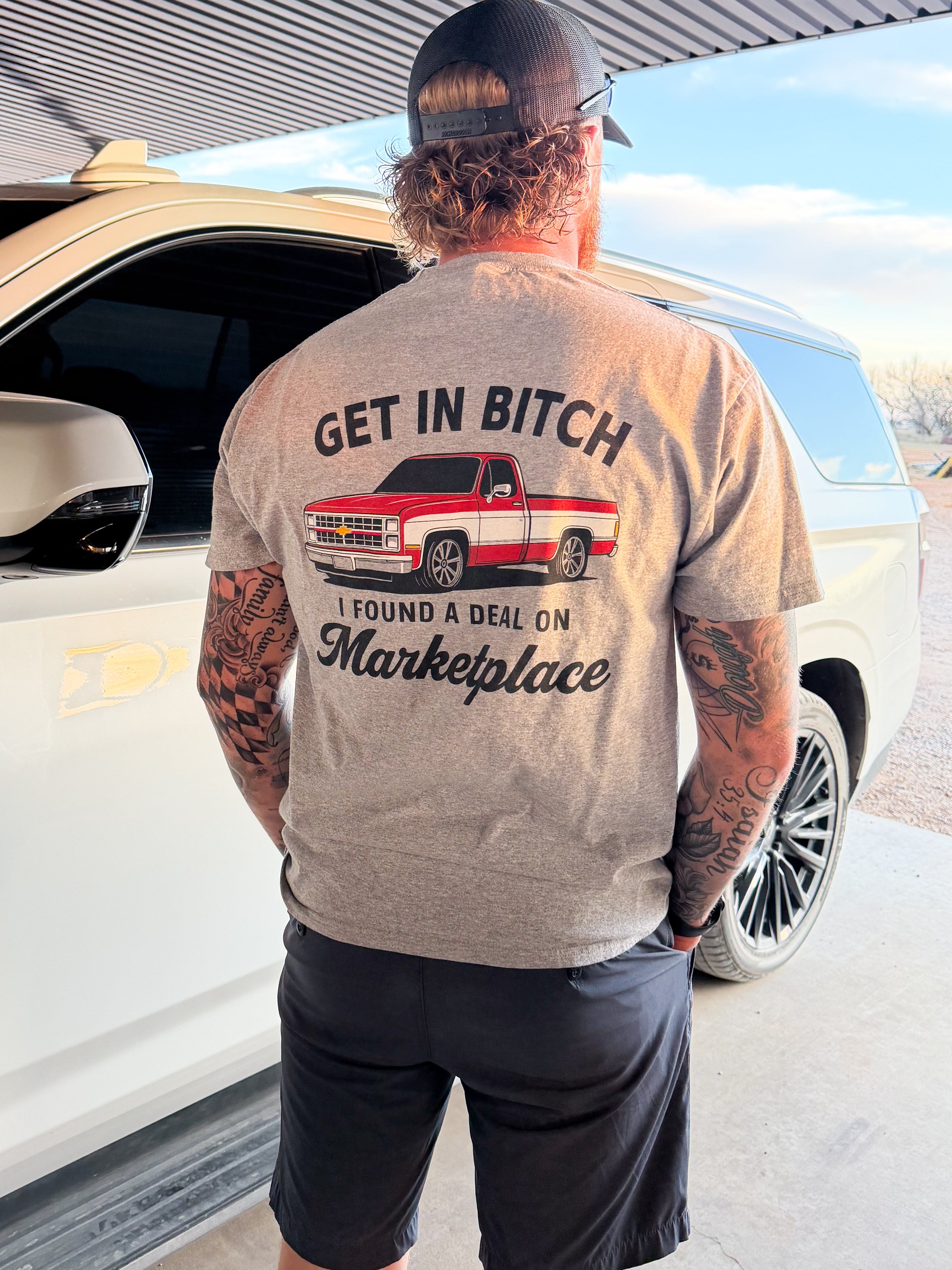 Shop Karma Tees graphic T-shirt featuring bold "Get In B*tch, I found a deal on Marketplace" text on white cotton fabric.