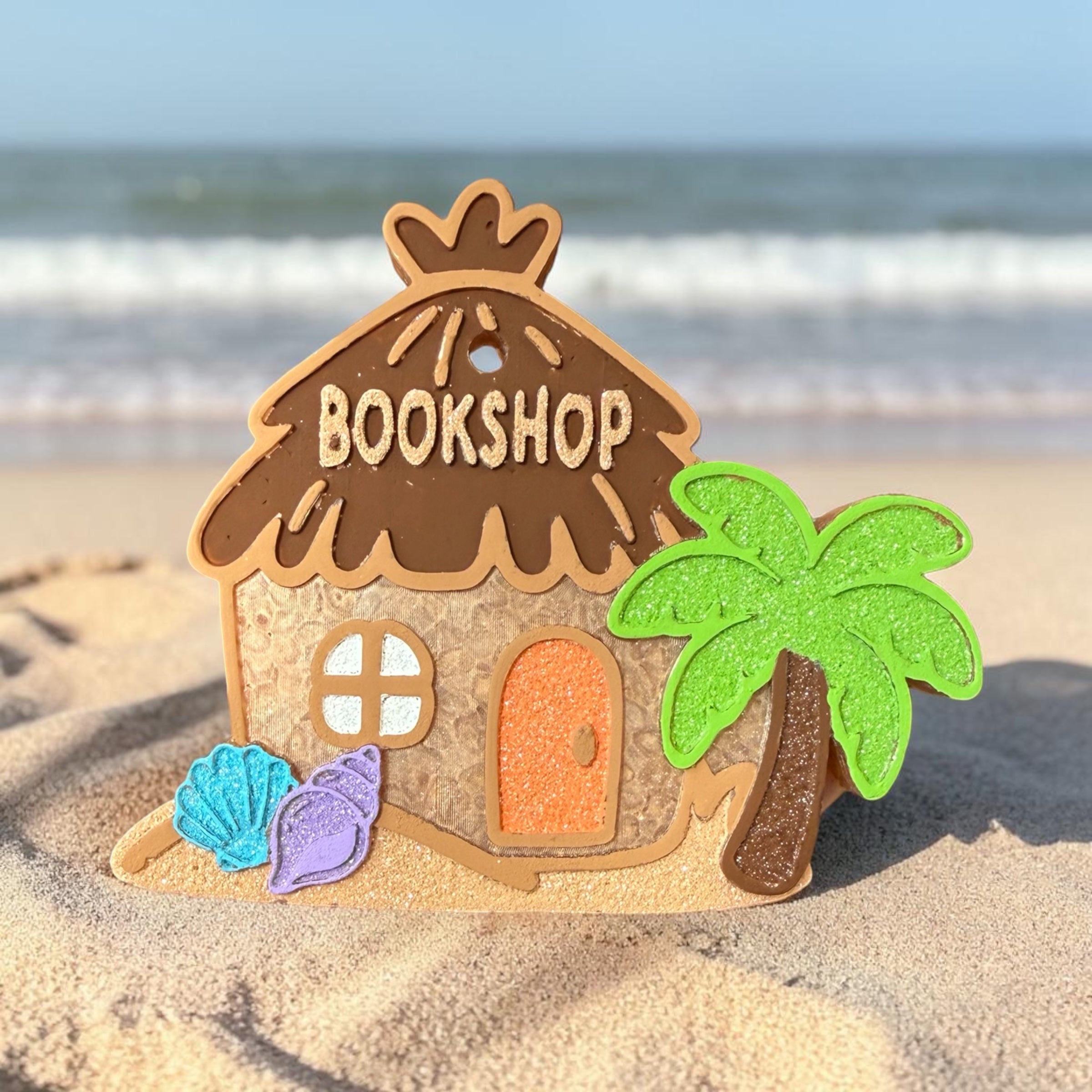 Books By The Sea Freshie by Bug & Bean Freshies, a decorative air freshener shaped like a book with seaside design.