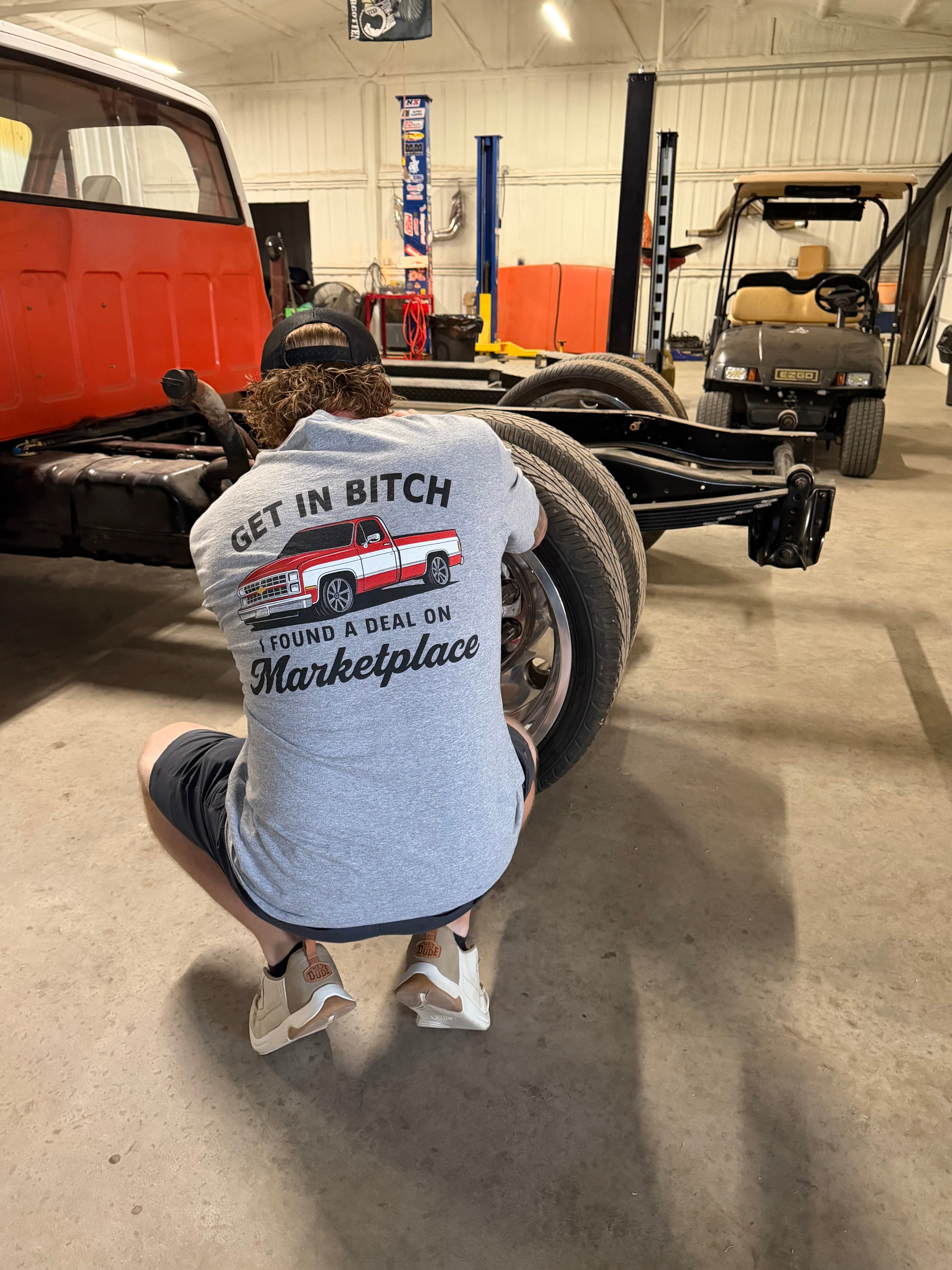 Shop Karma Tees "Get In B*tch, I Found a Deal" T-shirt with bold printed text on a casual cotton shirt.
