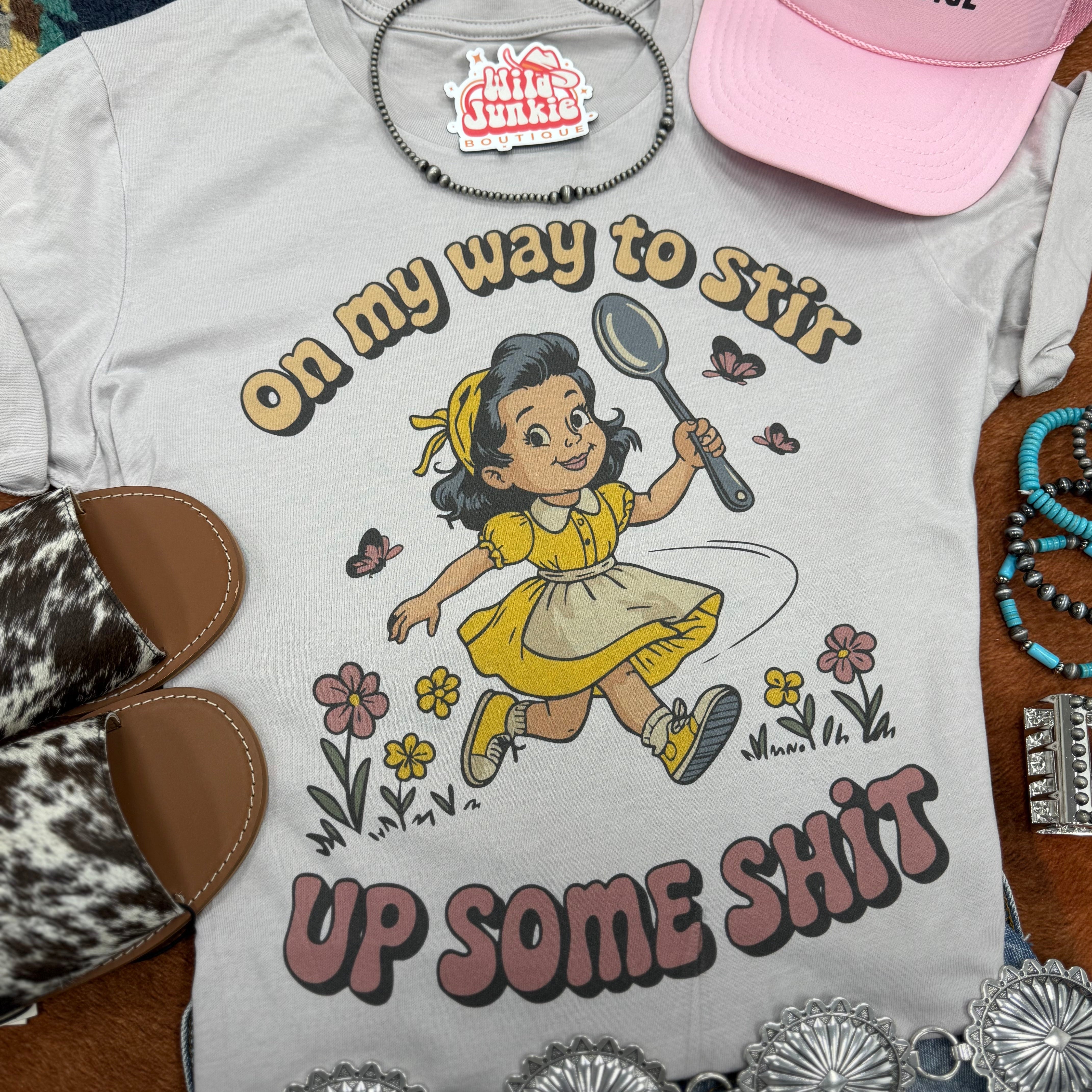 Wild Junkie graphic tee featuring bold "On My Way To Stir Up Some Shit" text in black on a white cotton T-shirt.