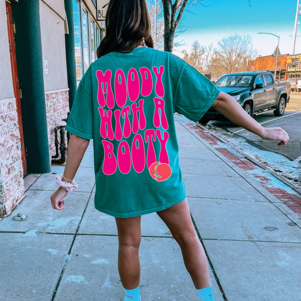 Moody with a Booty graphic T-shirt from Shop Karma Tees featuring a bold, colorful design on soft cotton fabric.