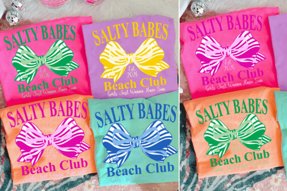 Salty Babes Beach Club graphic tee by Anchored Grace Boutique featuring a colorful beach-themed design on a casual t-shirt.