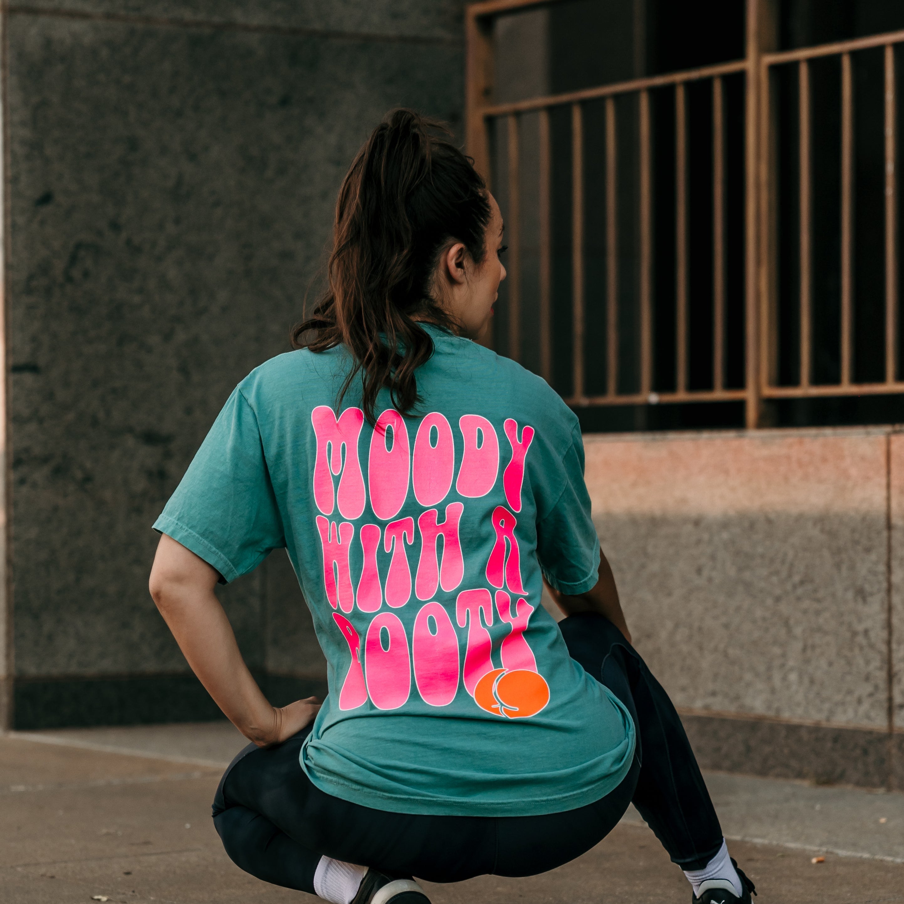 Moody with a booty graphic t-shirt by Shop Karma Tees, featuring bold print and casual fit on a white cotton tee.