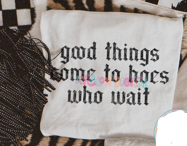 Black graphic tee from Anchored Grace Boutique with bold white text that reads "Good Things Come to Hoes Who Wait."