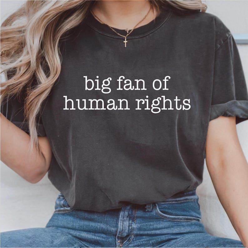 Black graphic tee by Anchored Grace Boutique featuring bold "Big Fan of Human Rights" text and eye-catching design.