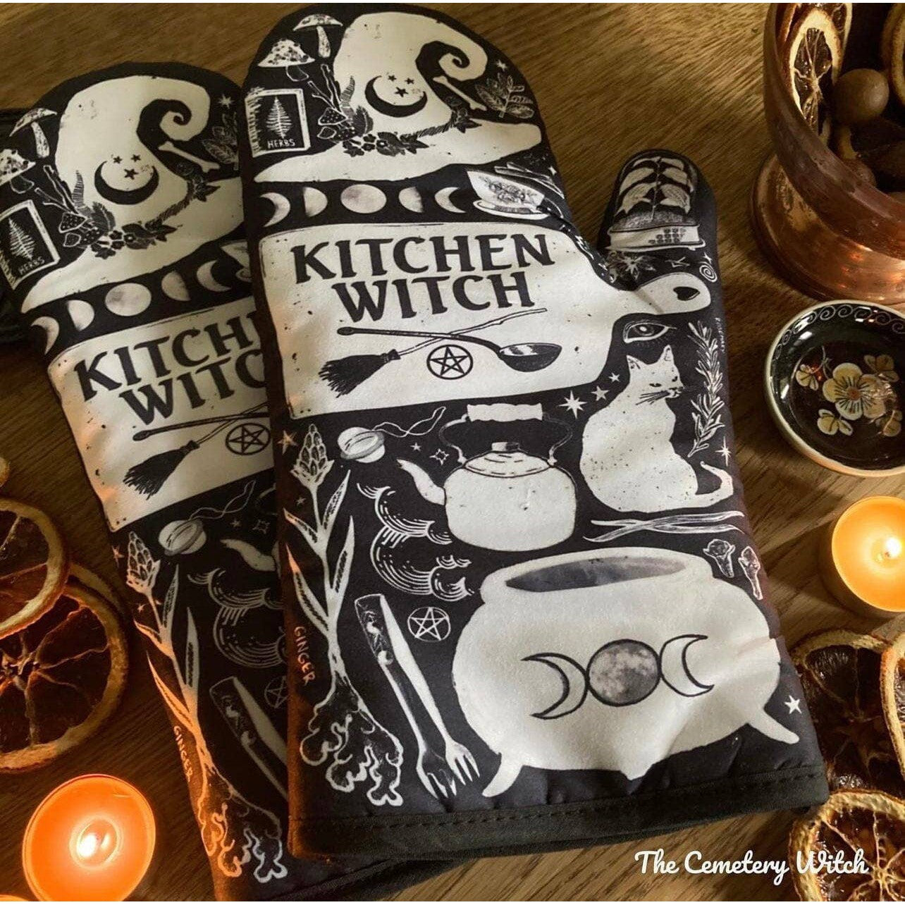 Set of 2 Kitchen Witch oven mitts and pot holders from The Bullish Store, hanging oven gloves with colorful witch design.