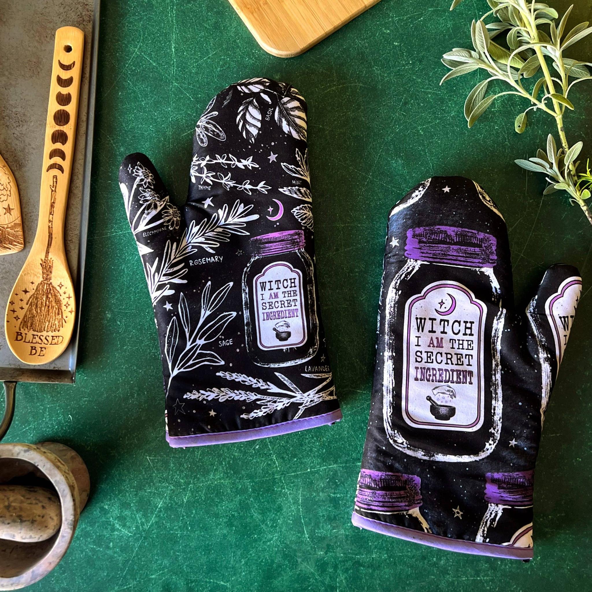 Set of 2 witch-themed oven mitts and pot holders from The Bullish Store, hanging and featuring "I AM The Secret Ingredient" design.