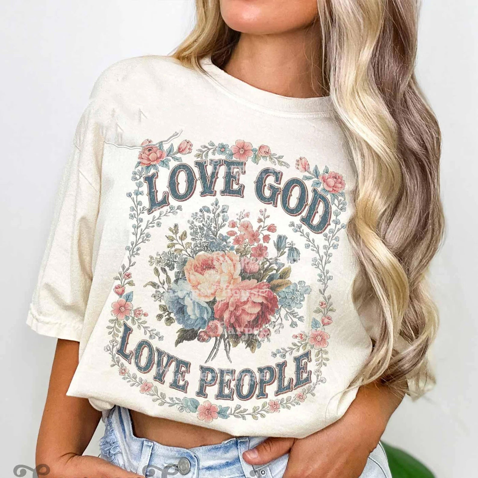 Love God Love People graphic tee by Anchored Grace Boutique featuring bold text and a stylish design on soft cotton fabric.