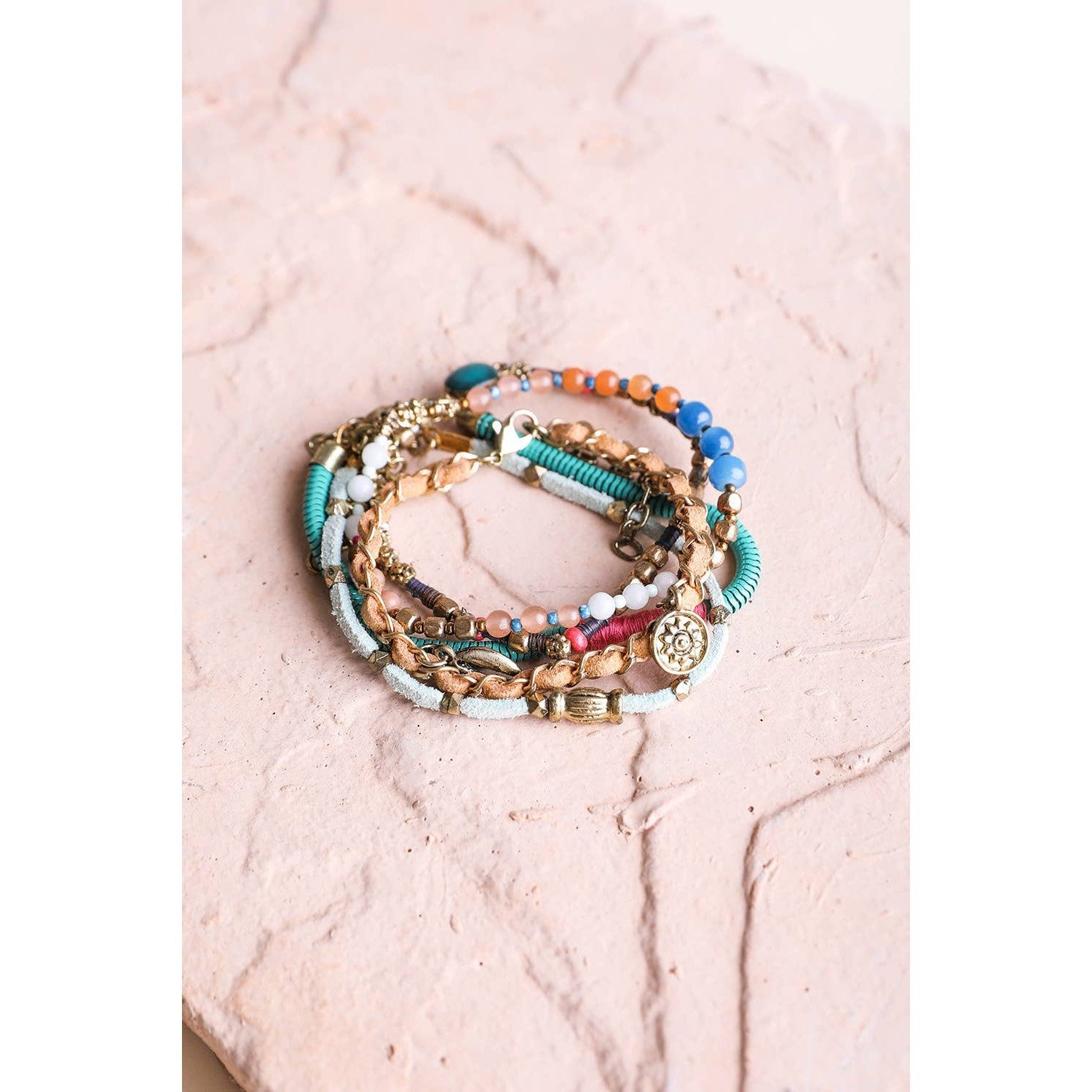 Stack of five teal multi-suede boho bracelets with layered design, featuring various textures and bead accents.