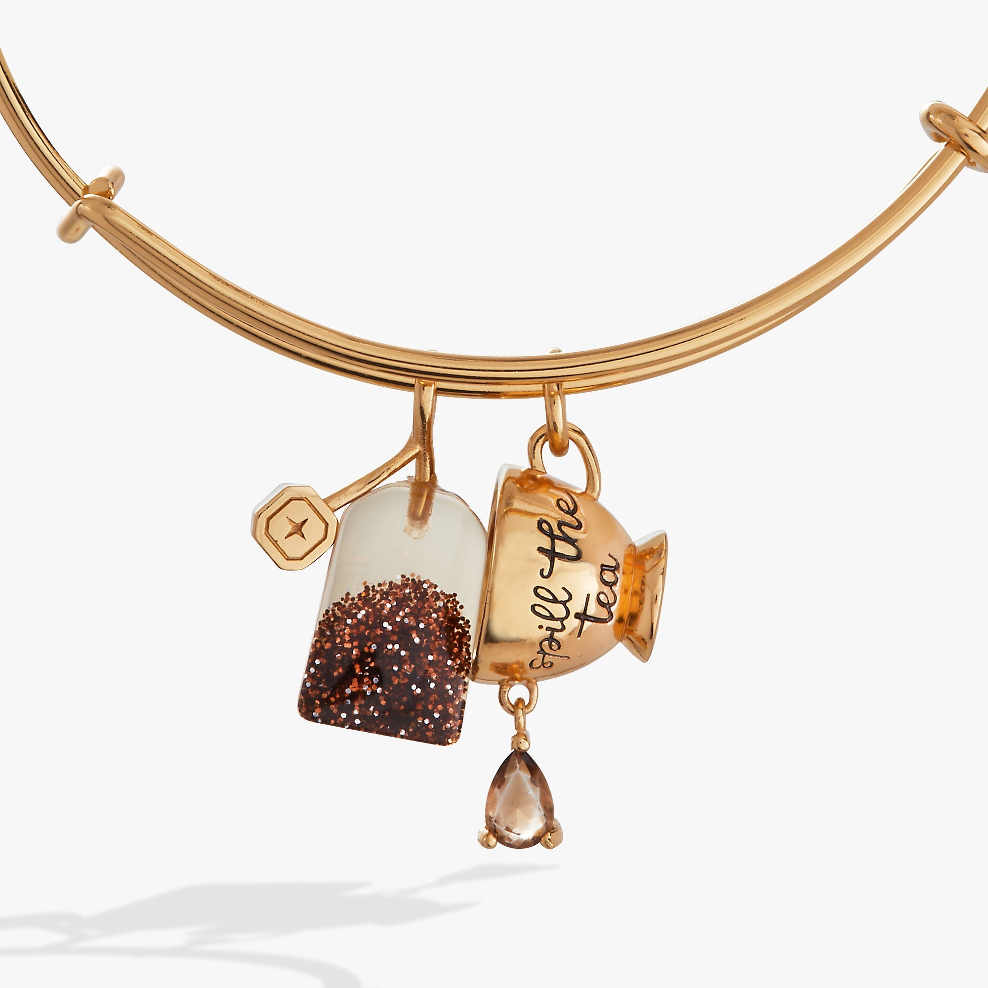 Gold ALEX AND ANI bracelet featuring a "Spill the Tea" cup and tea bag charm, stylish bangle accessory.
