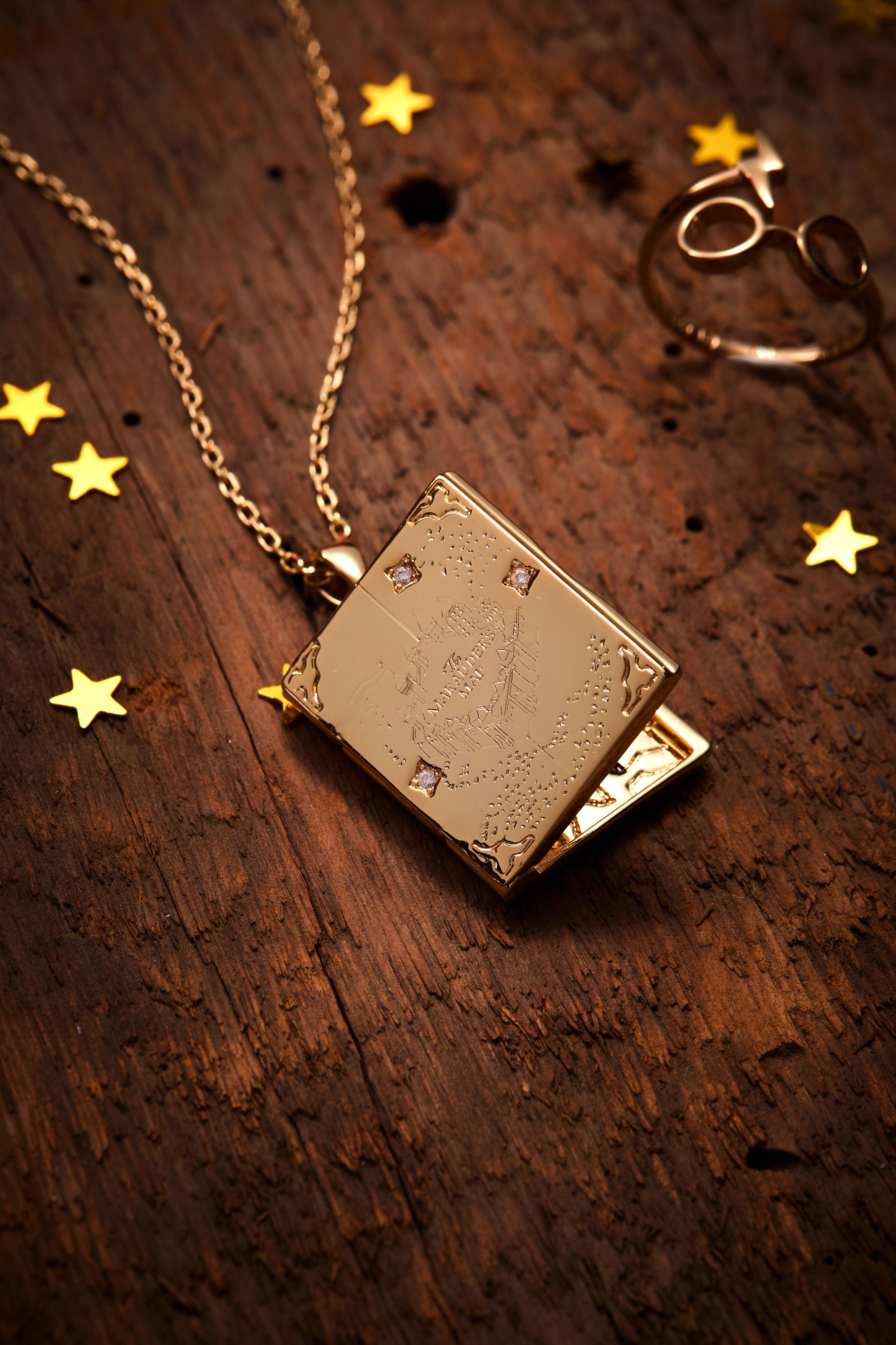 Gold Harry Potter Mischief Managed locket necklace by ALEX AND ANI featuring engraved Hogwarts crest and mystical design.