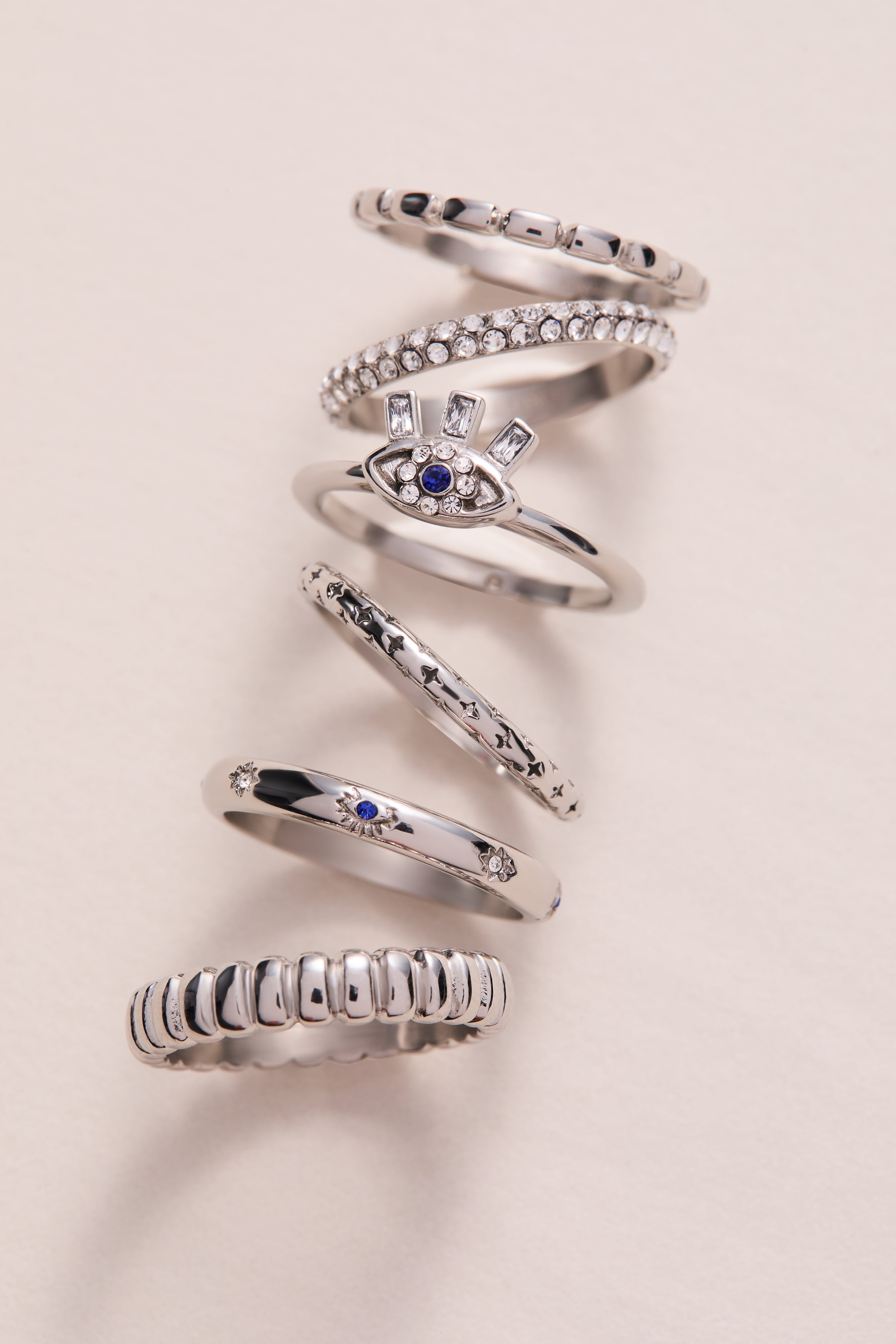 Set of three gold stainless steel Evil Eye stacking rings by ALEX AND ANI, featuring eye motifs and adjustable fit.