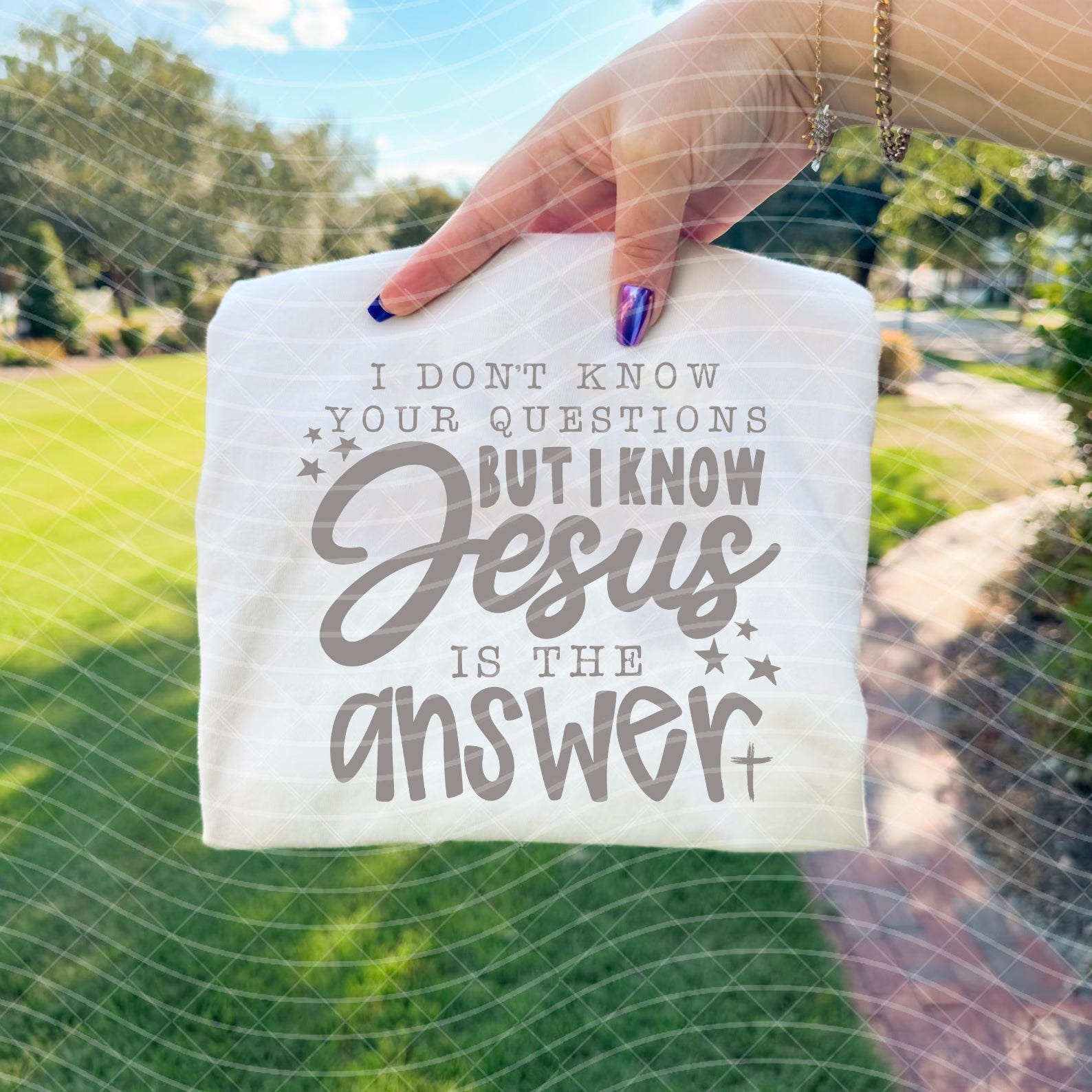 Black graphic tee with white text reading "I don't know your questions but I know Jesus is the answer," from Anchored Grace Boutique.