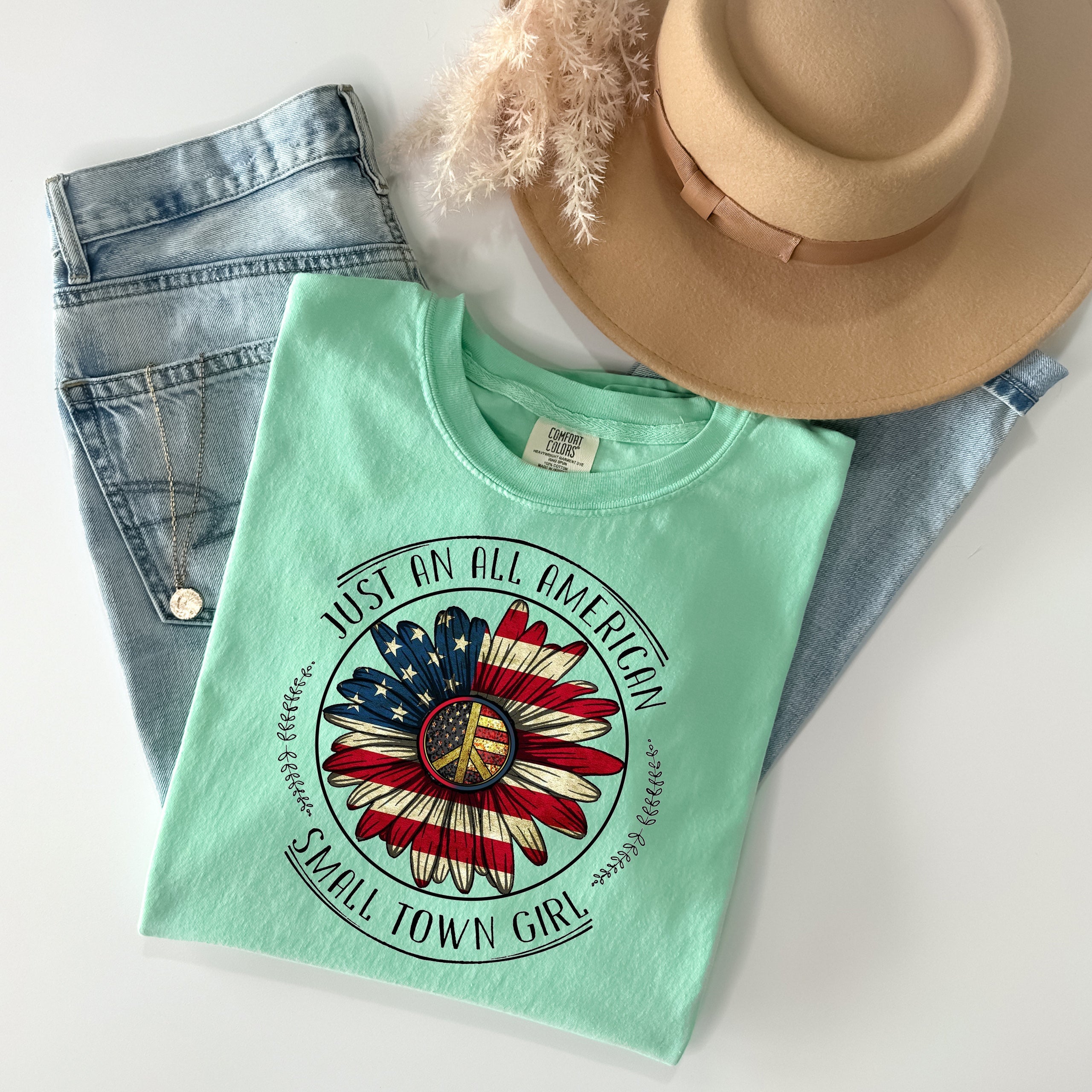 All American Small Town Girl graphic tee by Anchored Grace Boutique, featuring a casual cotton t-shirt with patriotic design and small-town charm.