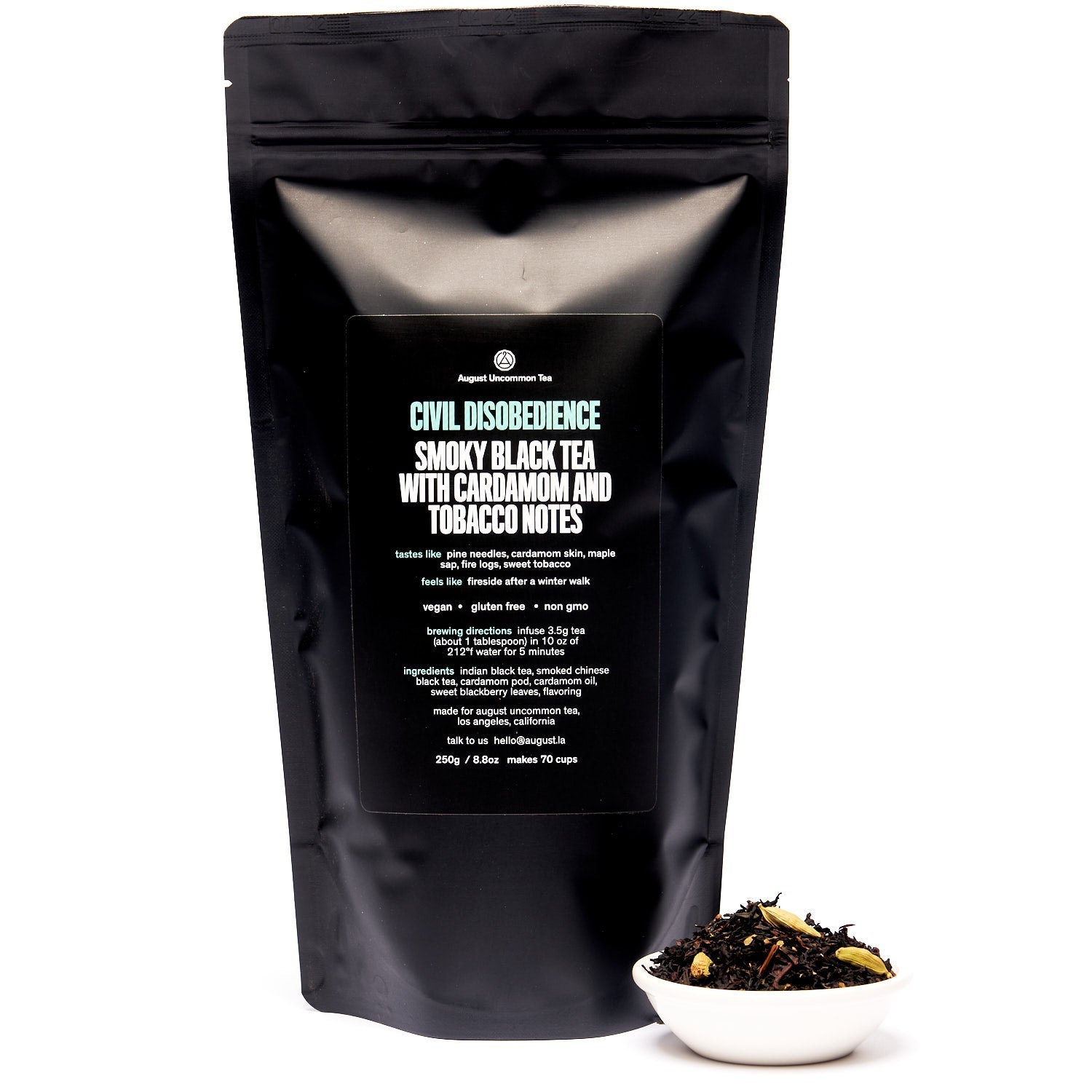 August Uncommon Tea Civil Disobedience Smoky Cardamom Black Tea in a 15-cup bag, featuring dark tea leaves and fragrant spices.