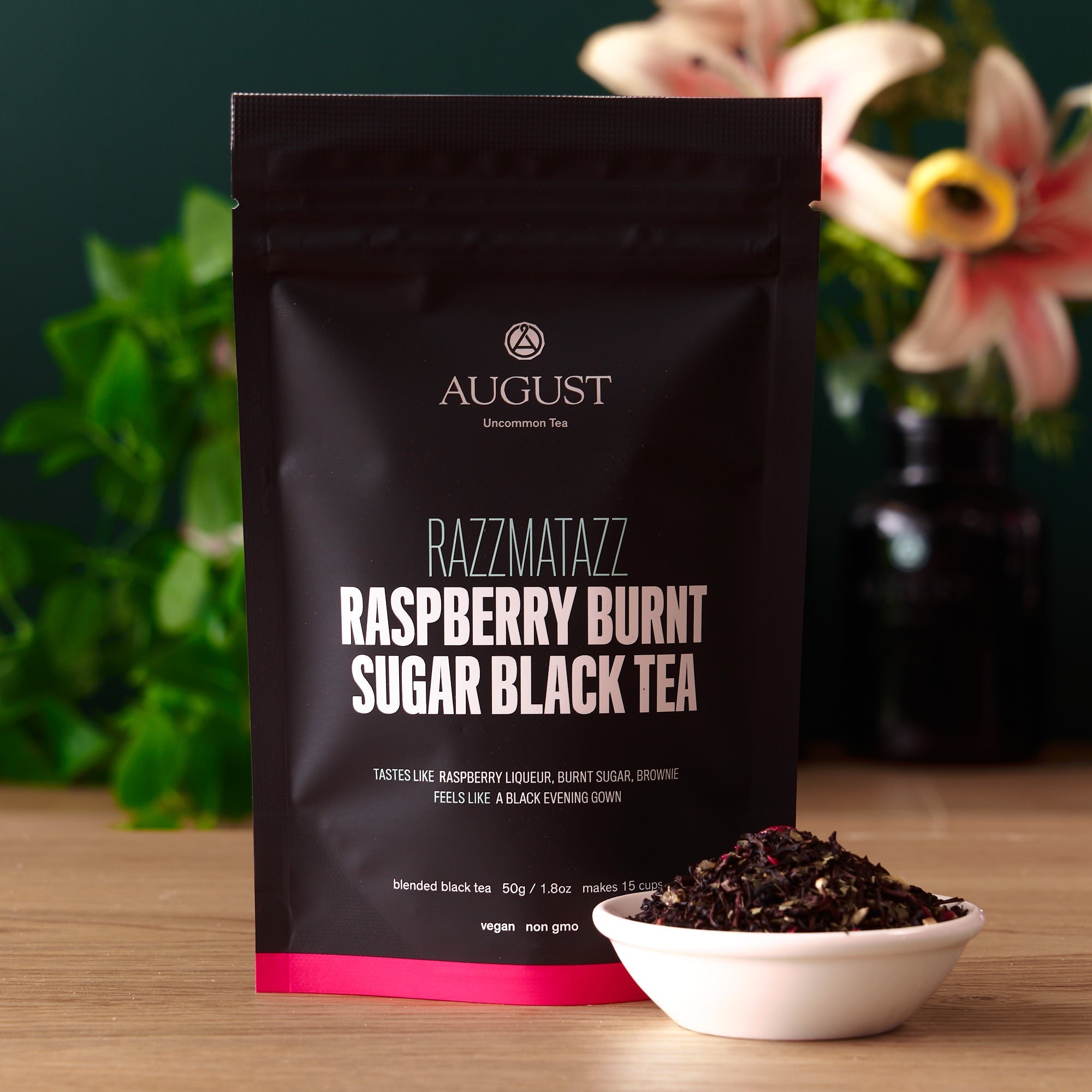 Razzmatazz Raspberry Burnt Sugar Black Tea bag from August Uncommon Tea, featuring a colorful label and tea bag inside.