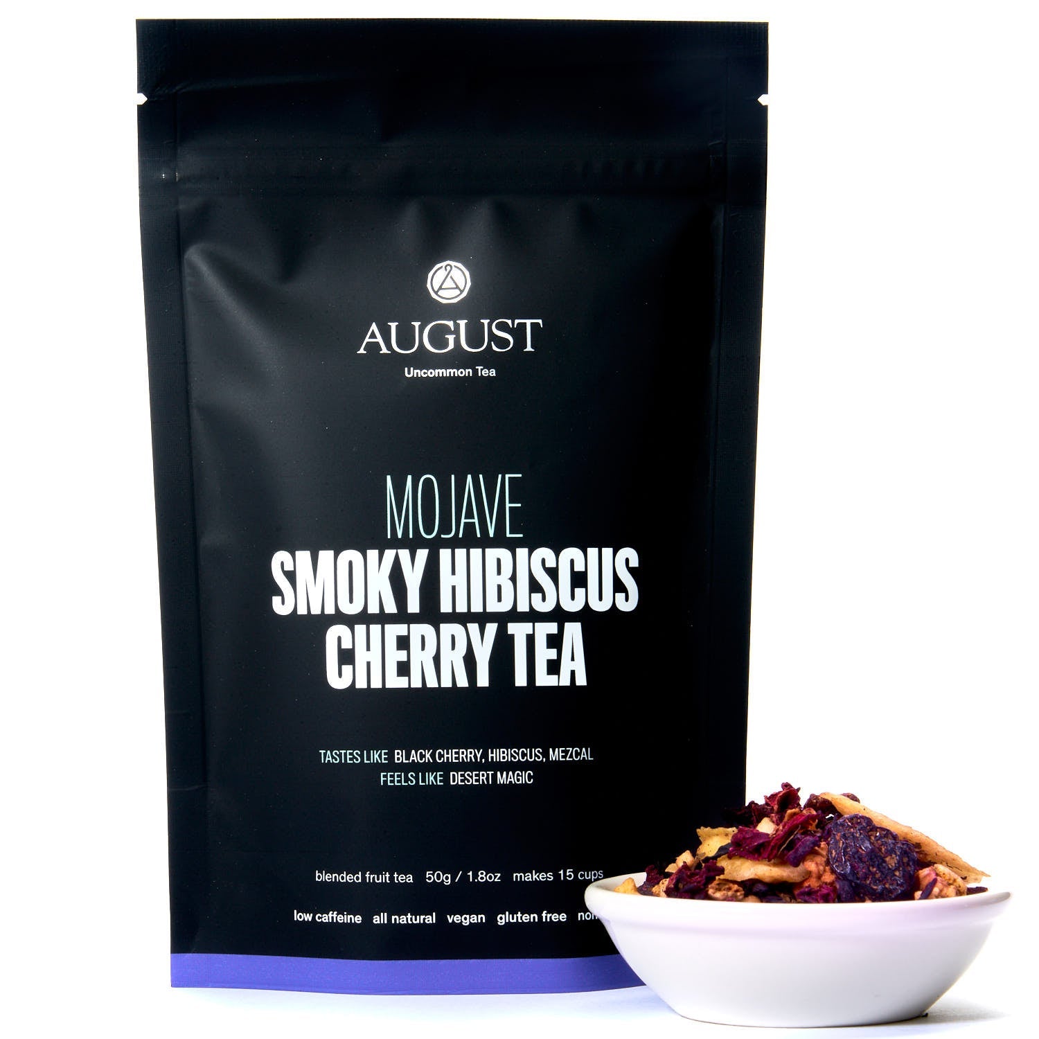August Uncommon Mojave Smoky Hibiscus Cherry Tea in a 15-cup herbal tea bag, low caffeine, vibrant red tea leaves and cherry blossoms.