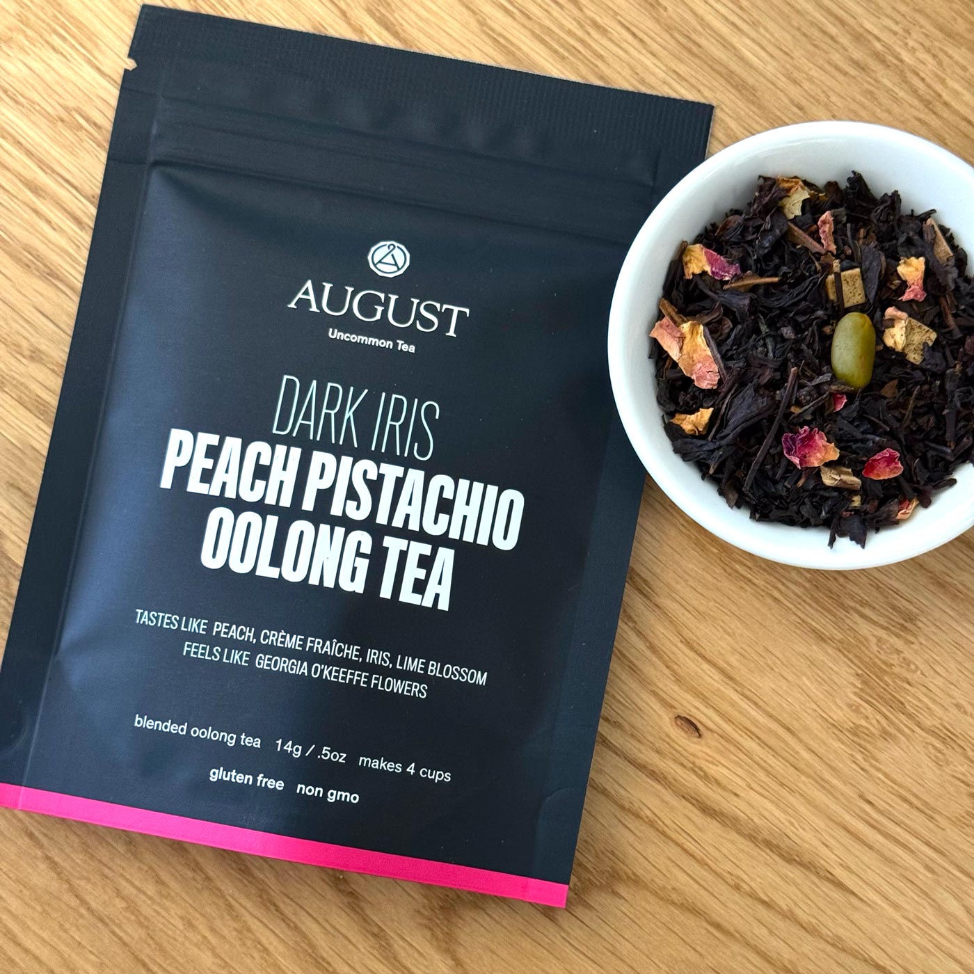 Dark Iris Peach Pistachio Oolong Tea tin from August Uncommon Tea, showcasing the elegant packaging and tea leaves inside.