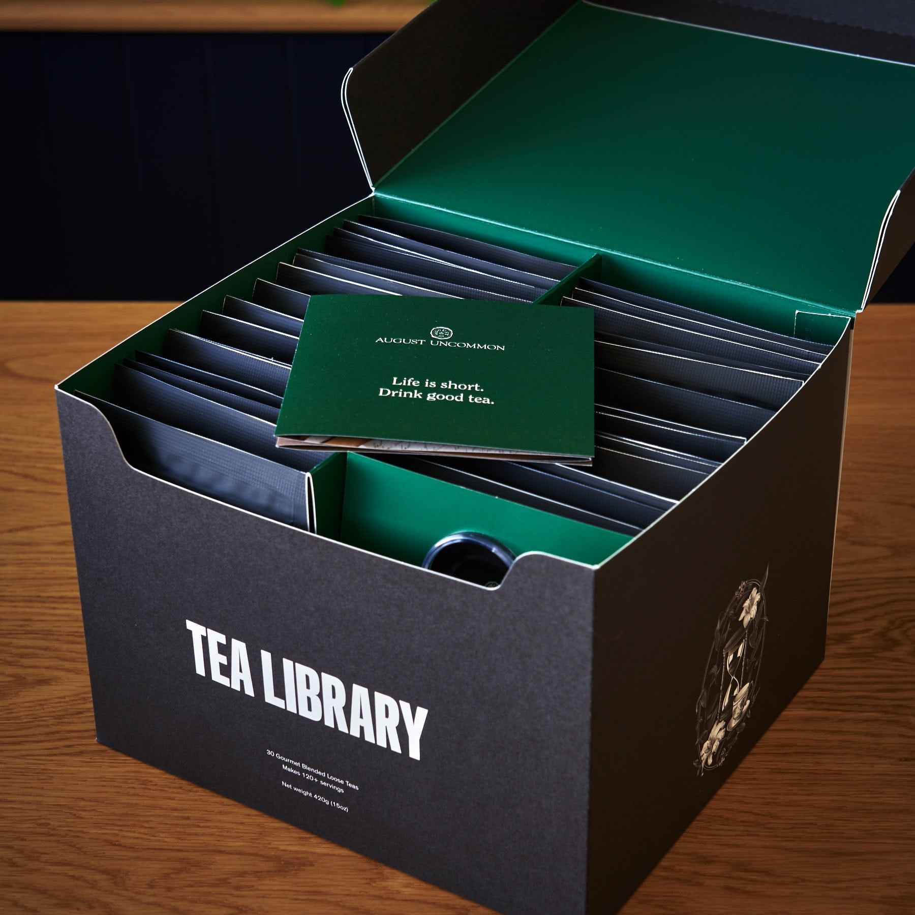 August Uncommon Tea Deluxe 30 Tea Sampler box with assorted tea packages, showcasing a variety of tea flavors in elegant packaging.