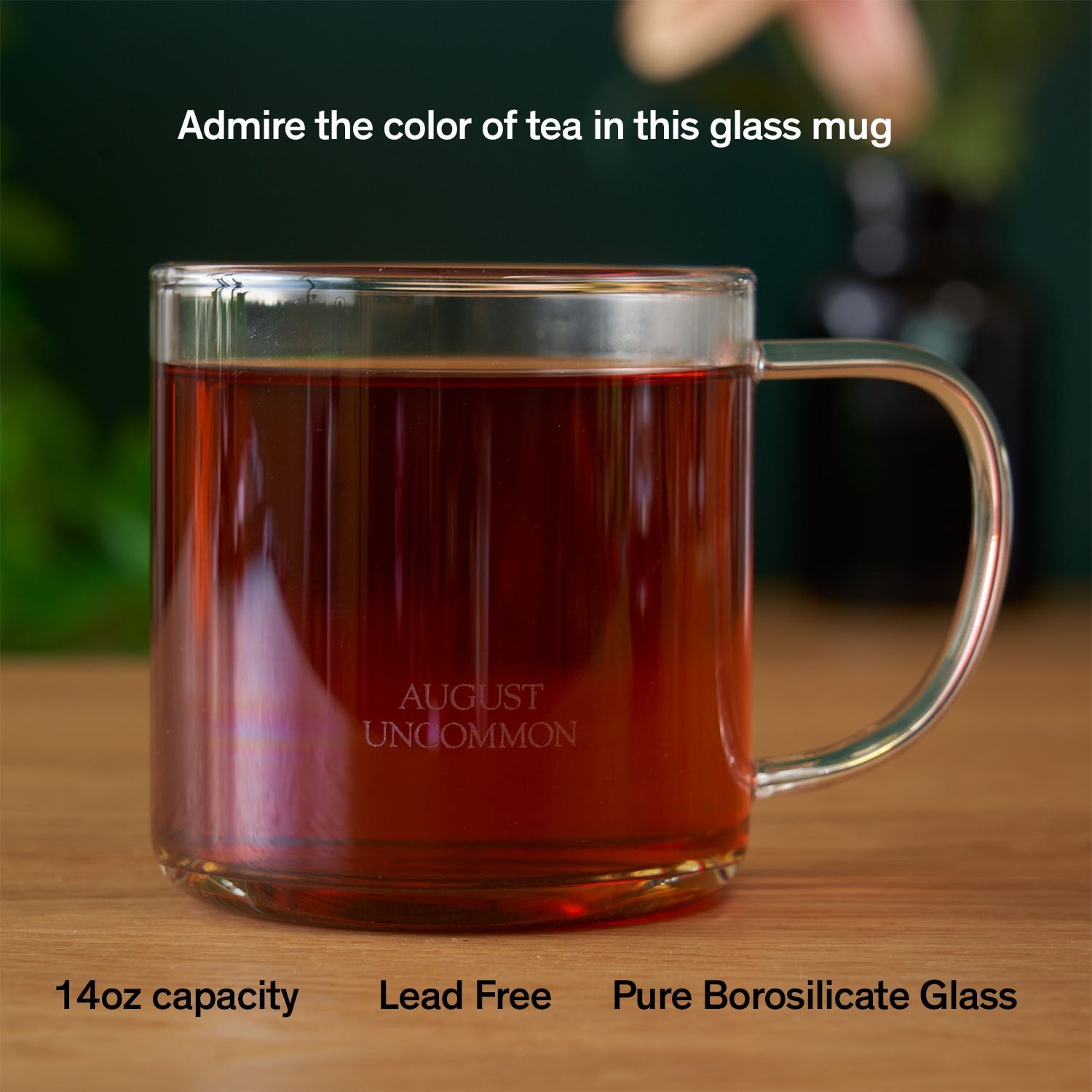 Clear glass mug from August Uncommon Tea, elegant teaware for hot beverages, showcasing its transparent design and sleek style.