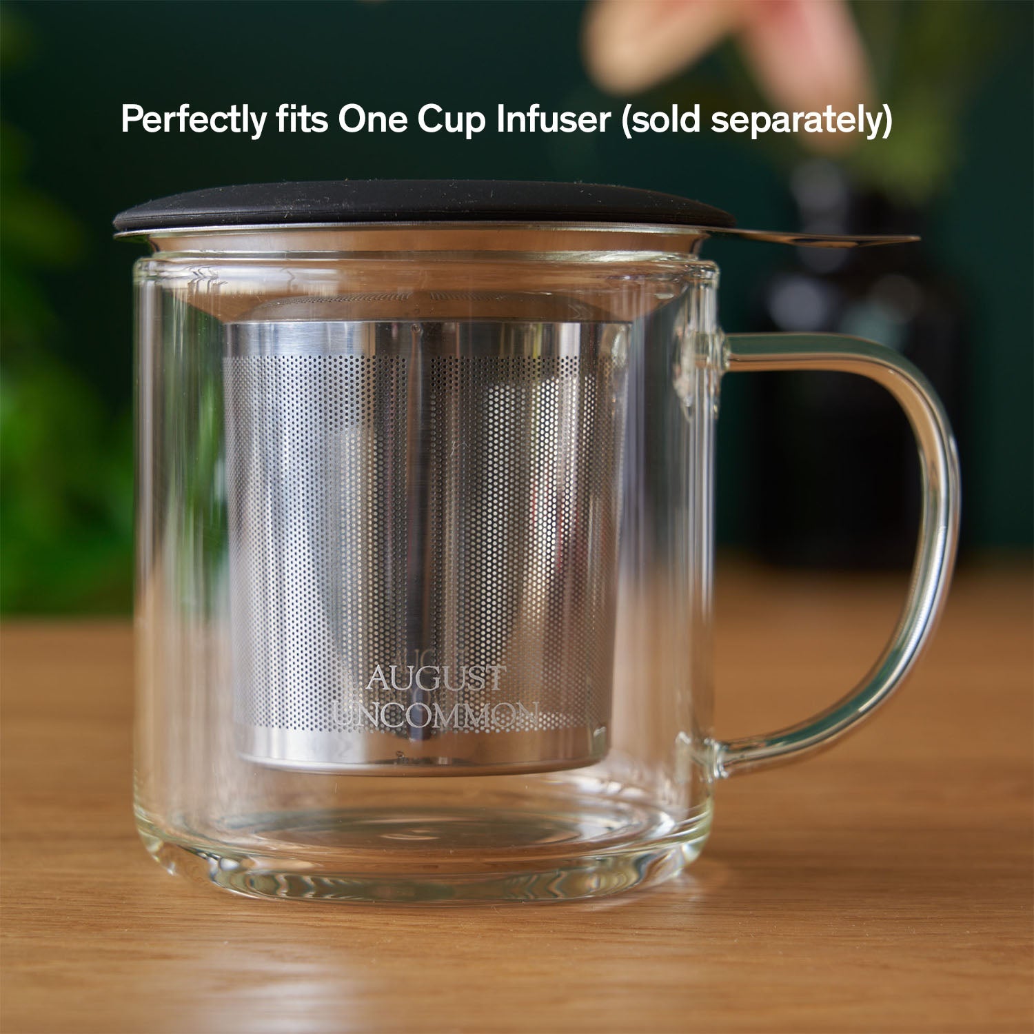 Clear glass mug from August Uncommon Tea, elegant teaware for hot beverages, showcasing its transparent design and smooth handle.