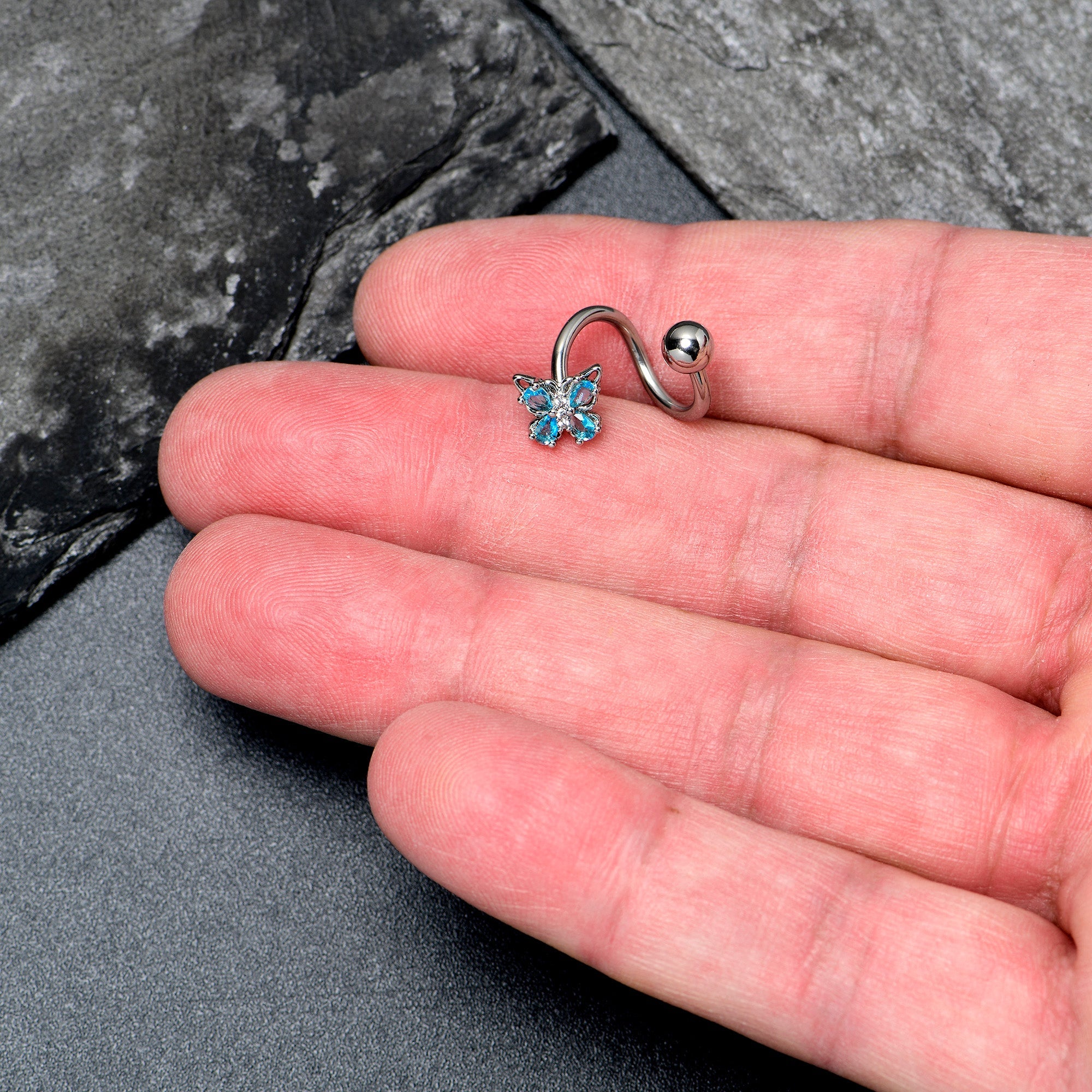 Blue Gem Baroque Butterfly Spiral Belly Ring by BodyCandy featuring a twisted spiral design with a decorative blue gemstone.