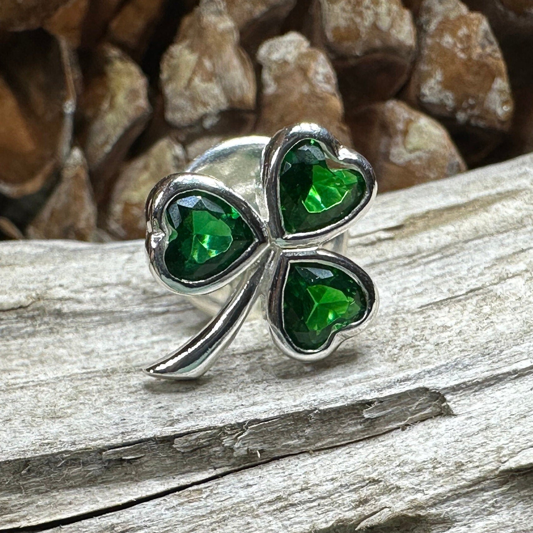 Irish Emerald Shamrock lapel pin by Celtic Crystal Design Jewelry, featuring a green emerald shamrock on a silver lapel pin.