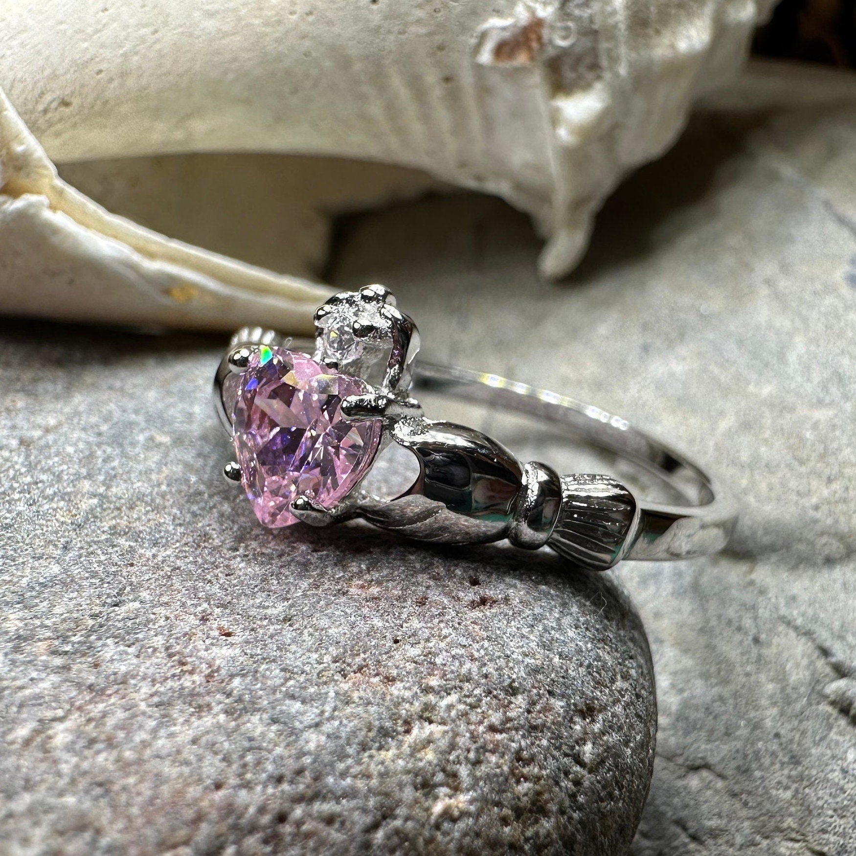 Petal pink Claddagh ring by Celtic Crystal Design Jewelry featuring intricate Celtic detailing and a delicate light pink gemstone.