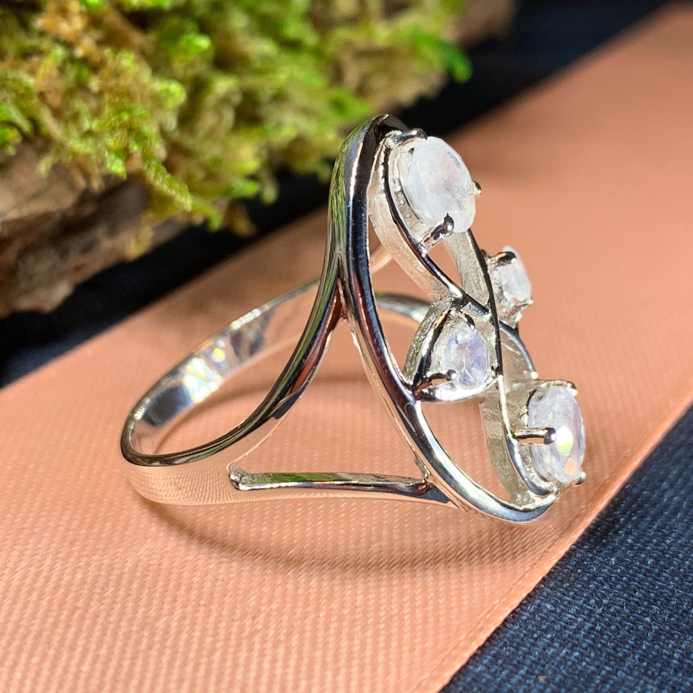 Celtic Crystal Design Jewelry moonstone infinity ring with intricate Celtic patterns and a smooth, polished moonstone centerpiece.