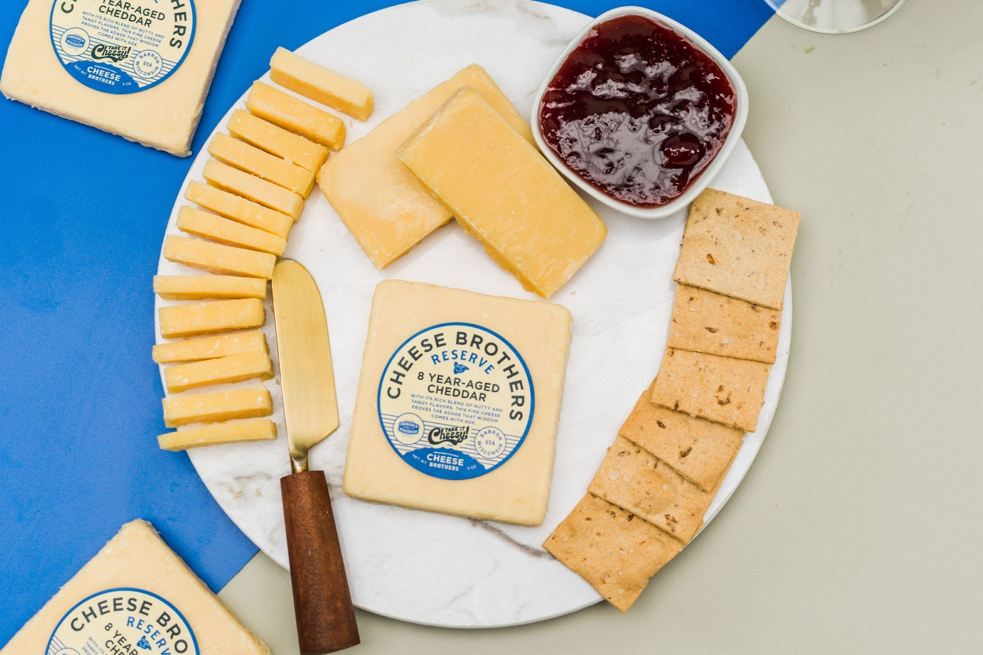 A wedge of 8-year-aged cheddar cheese from Cheese Brothers, Inc., showing its firm texture and rich orange color.