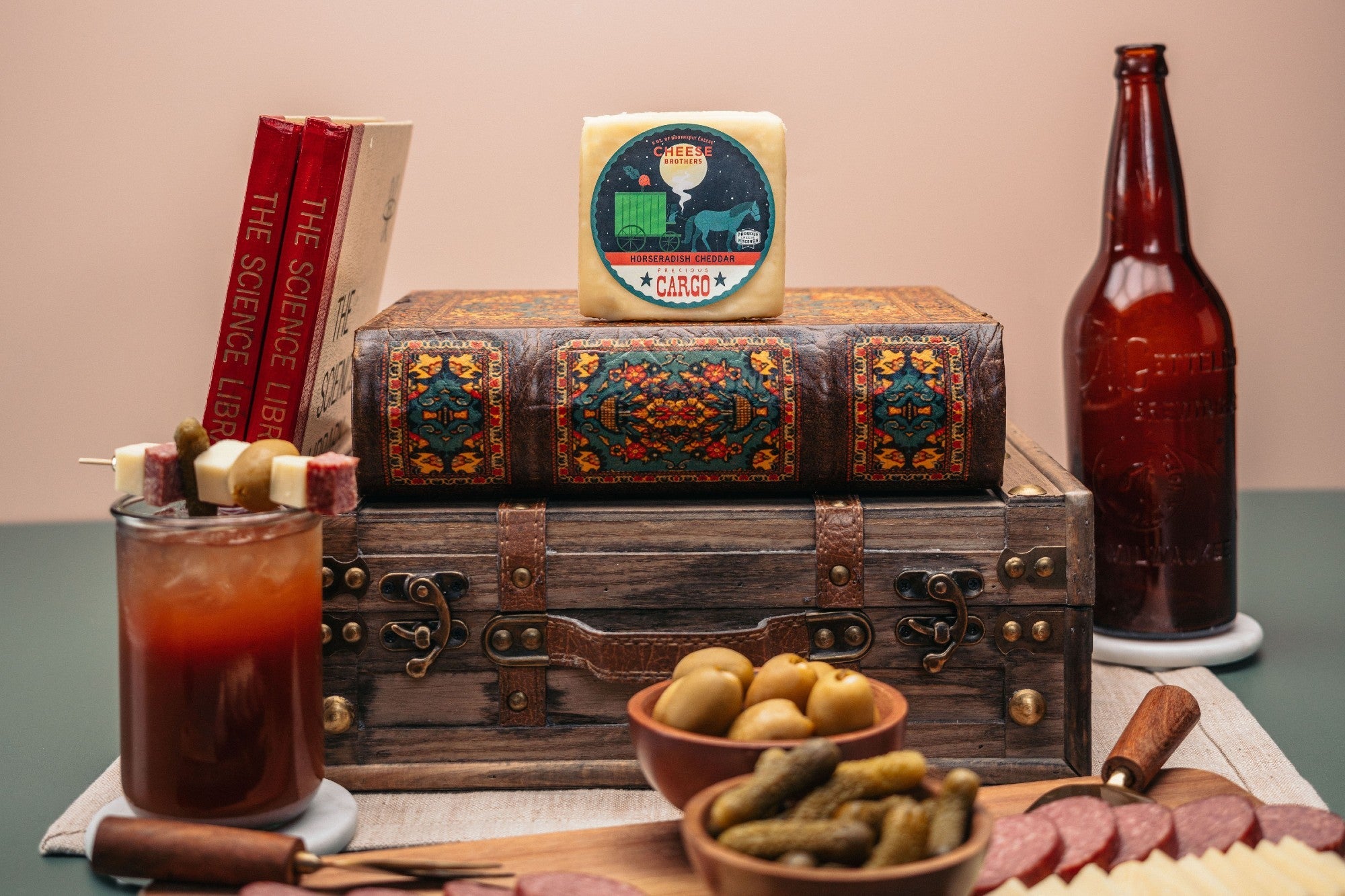 Slices of Precious Cargo Horseradish Cheddar cheese from Cheese Brothers, Inc. displayed on a wooden board with crackers