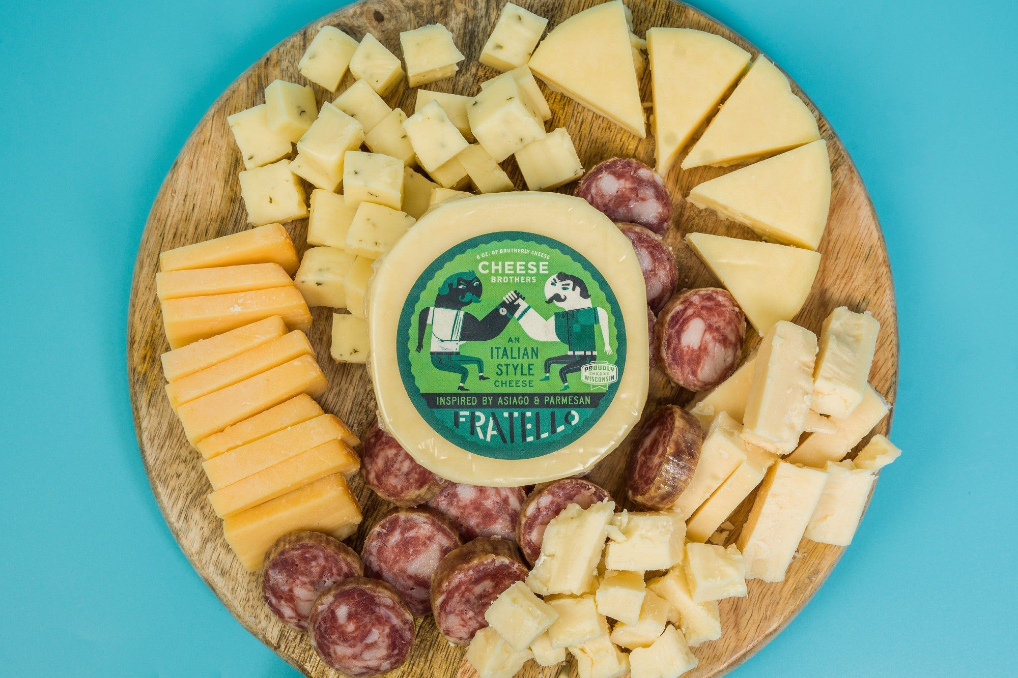 Assorted cheese and cured meats in a charcuterie gift box from Cheese Brothers, Inc., arranged with crackers and accompaniments.