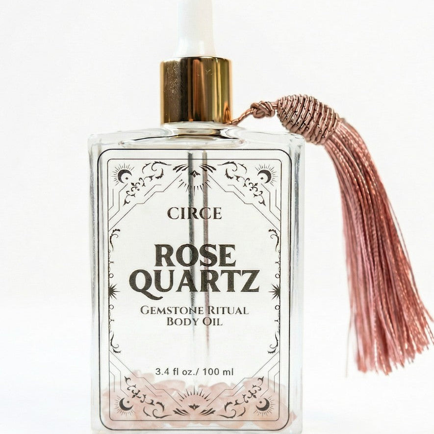 Rose quartz body oil from Circe Boutique, featuring a 3.4 oz bottle with rose quartz crystals for self-love and glowing skin.
