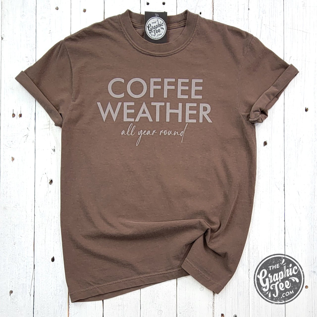 The Graphic Tee Coffee Weather All Year Round pigment dyed short sleeve graphic T-shirt showing a coffee-themed design on soft fabric.