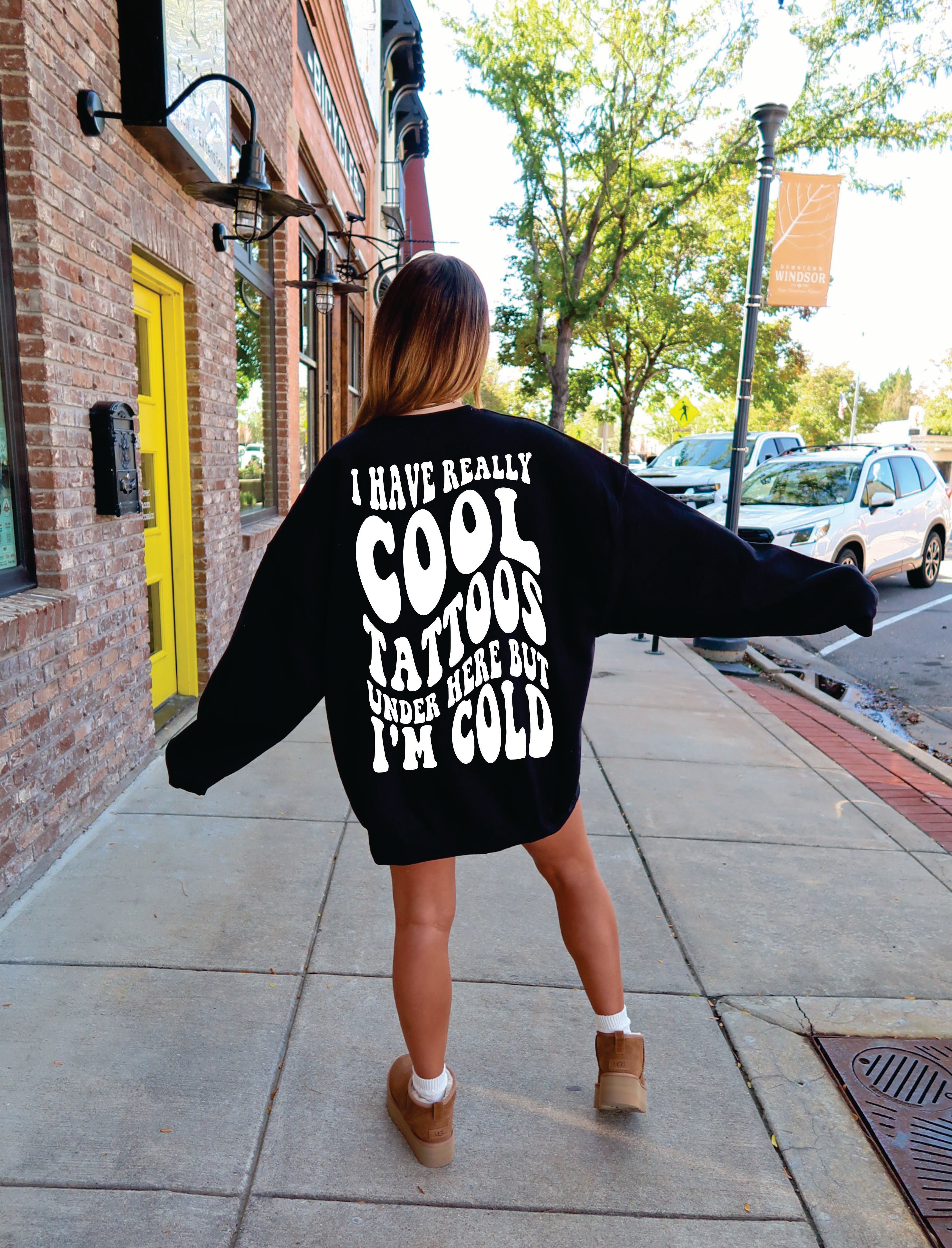 Gray crewneck sweatshirt featuring "I Have Really Cool Tattoos, But I'm Cold" printed design, casual and comfortable for everyday wear.