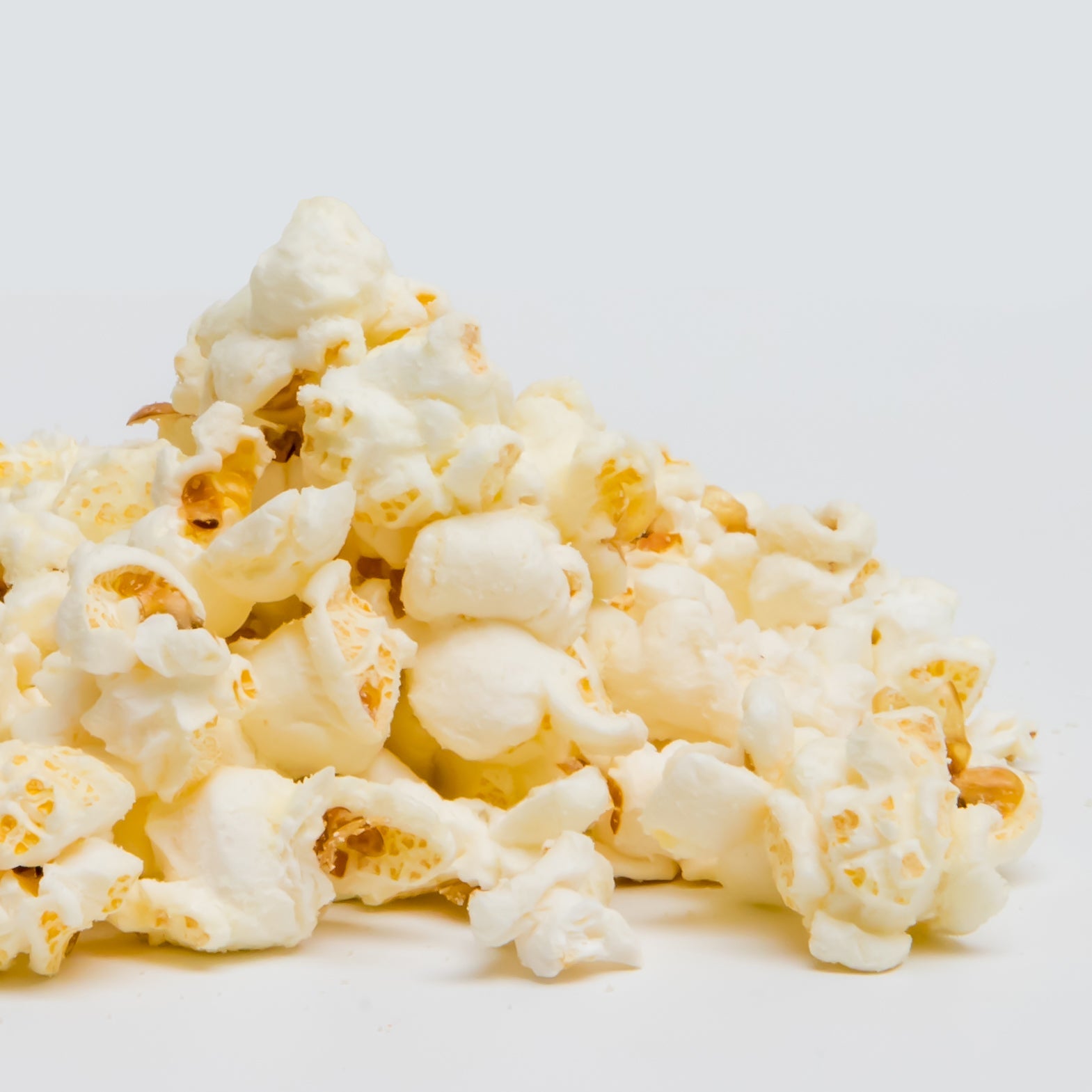 White cheddar popcorn by Colorado Popcorn Company in a 2 oz bag, showcasing crispy popcorn coated with white cheddar cheese flavor.