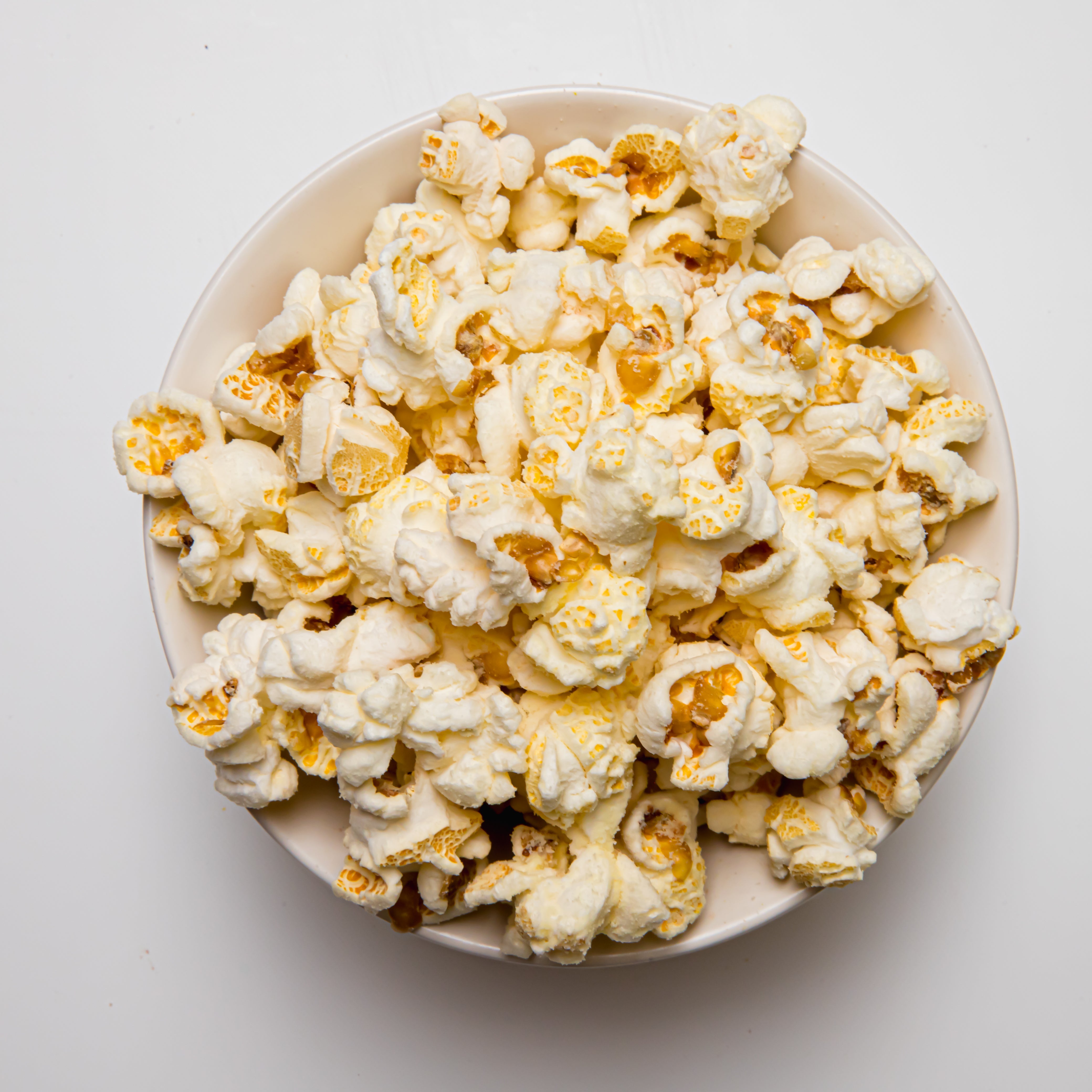 White Cheddar popcorn by Colorado Popcorn Company in a 2 oz bag, showing golden popcorn coated with white cheddar cheese.
