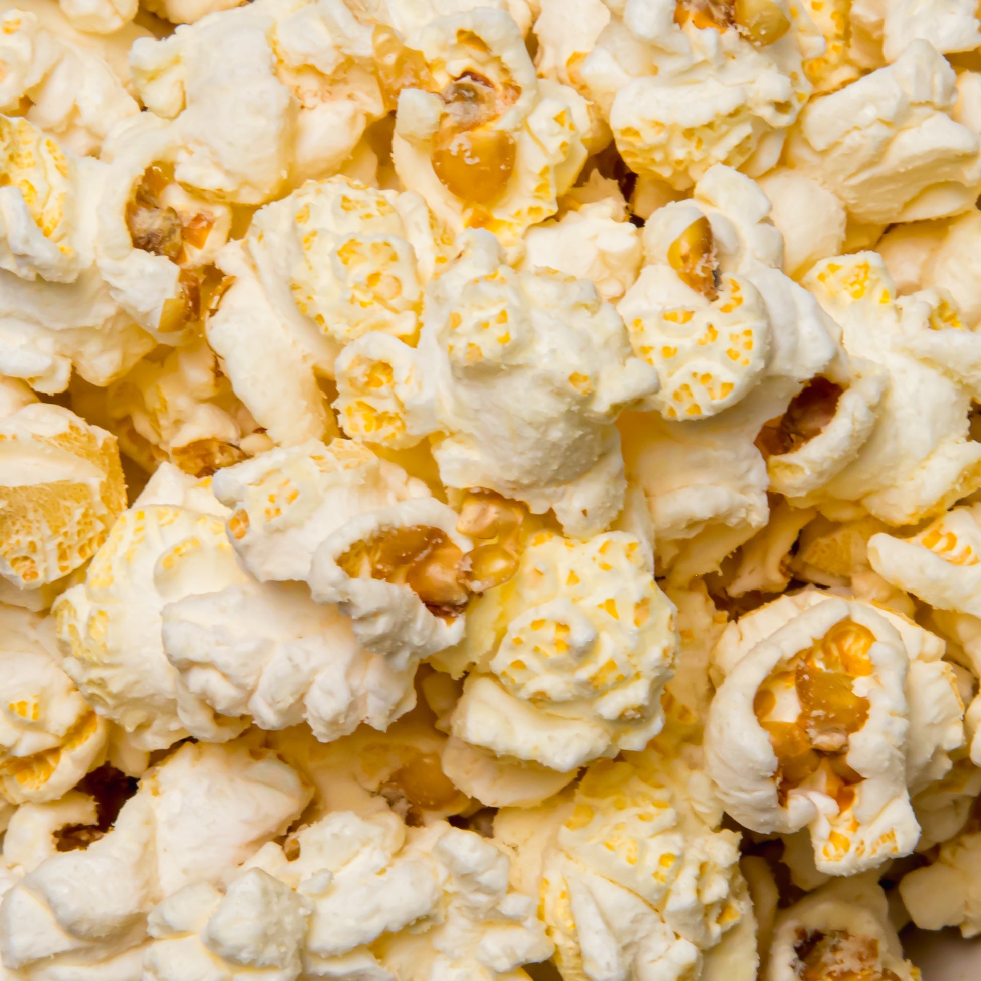 White cheddar popcorn from Colorado Popcorn Company in a 2 oz bag, showing crispy popcorn coated with creamy white cheddar flavor.